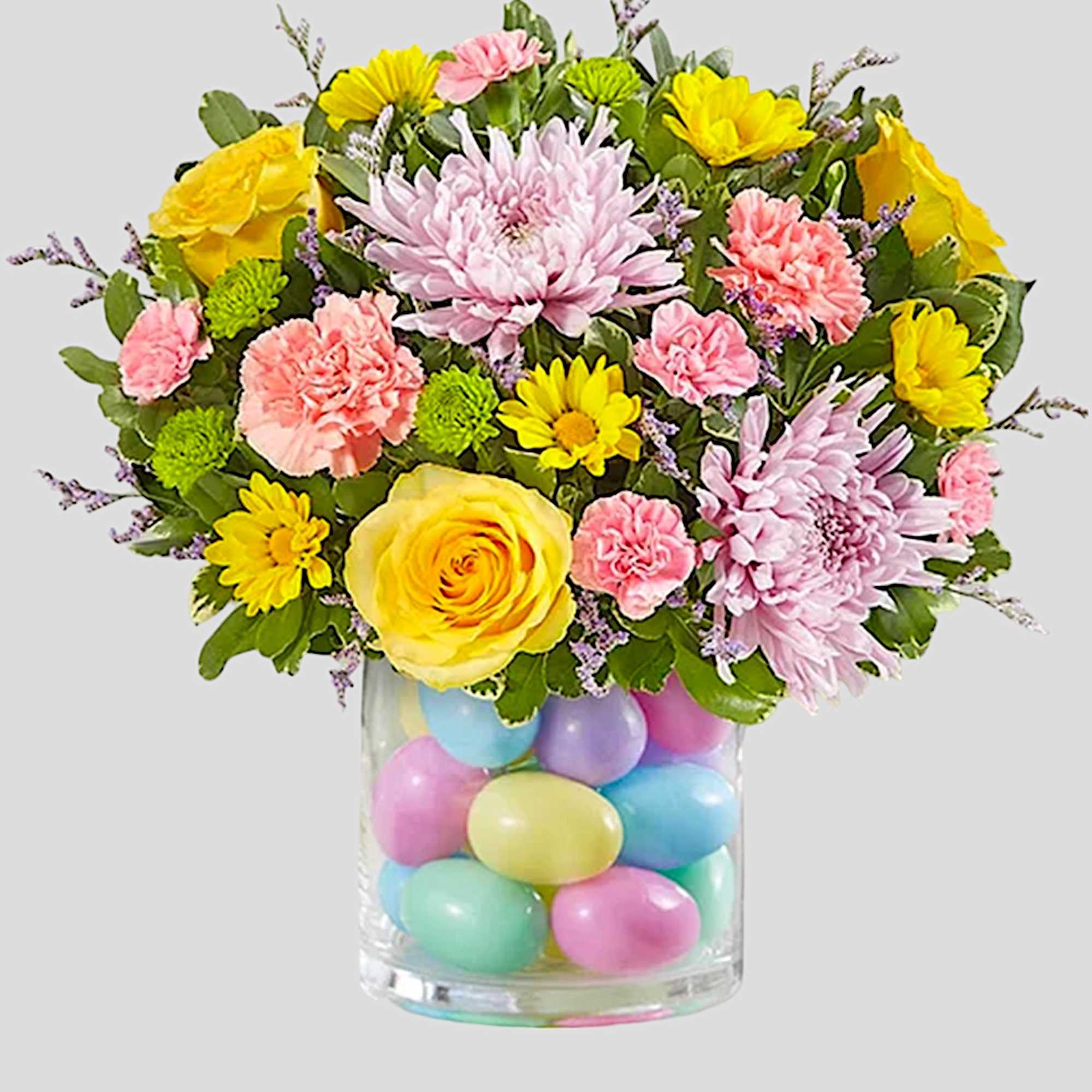 Colorful bouquet in a clear vase filled with pastel eggs