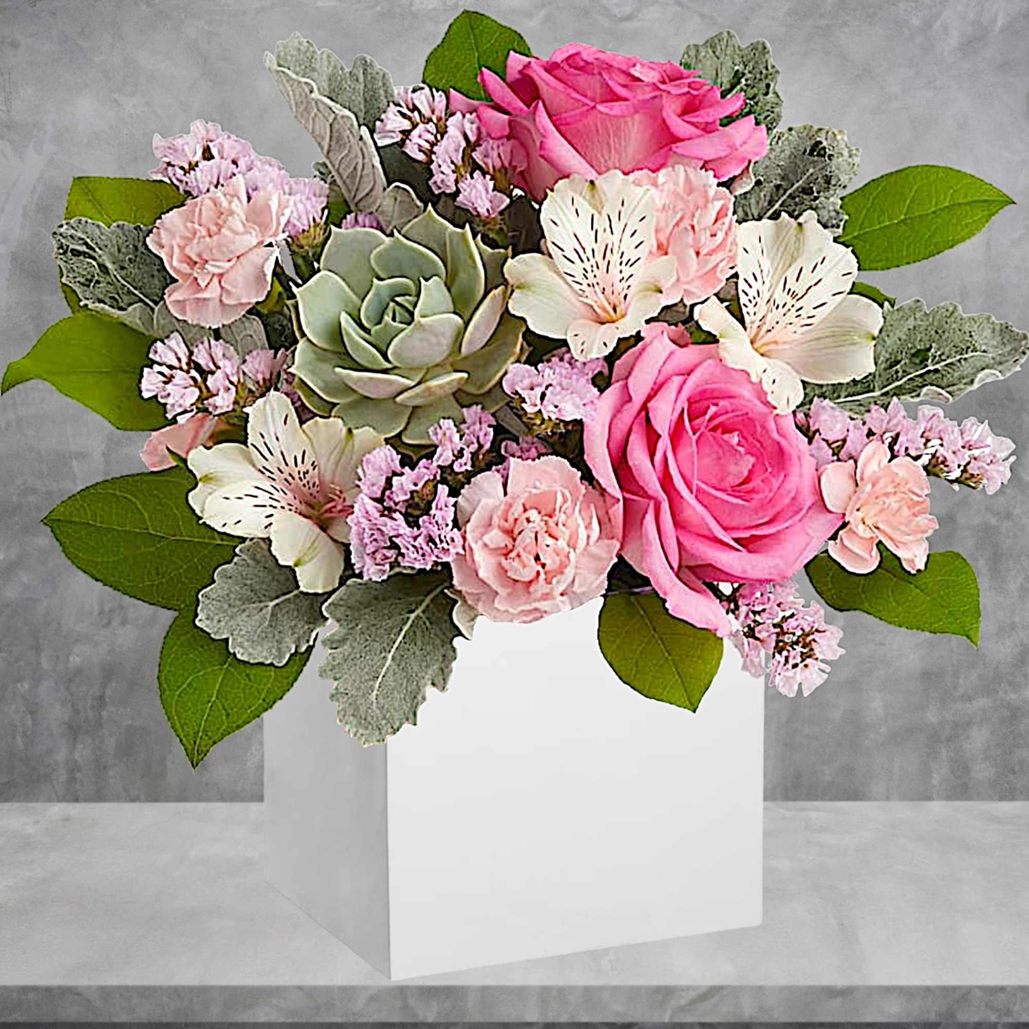 Pink roses and pale flowers arranged in a white box