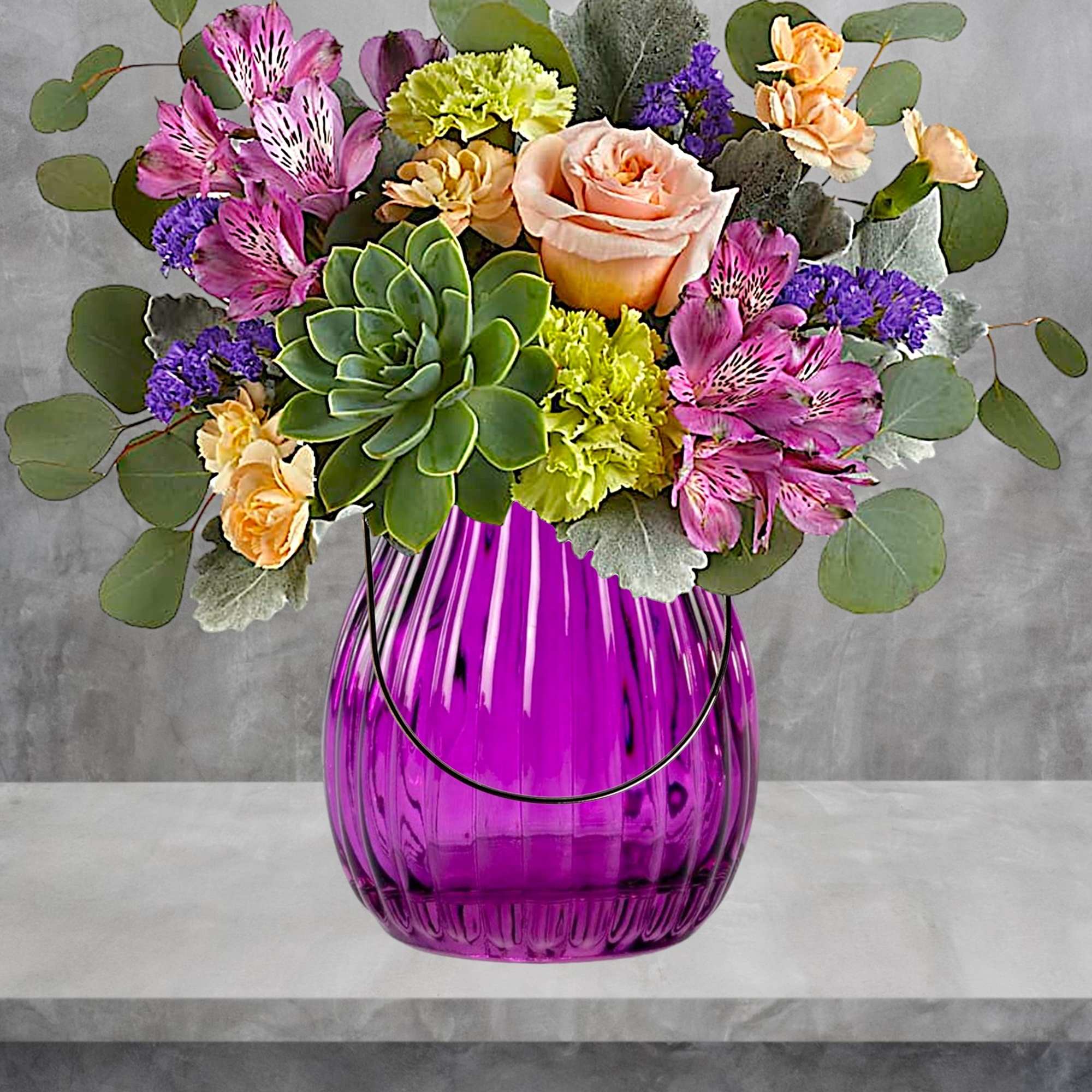 Mixed bouquet in a purple glass vase with a succulent and roses