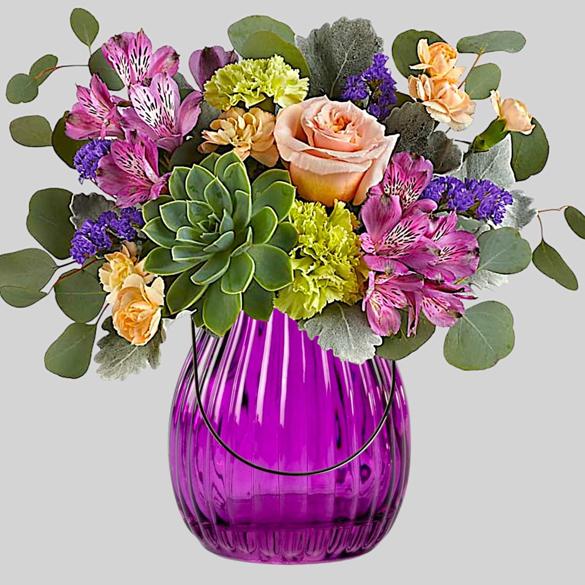 Mixed bouquet in a purple glass vase with a succulent and pink flowers