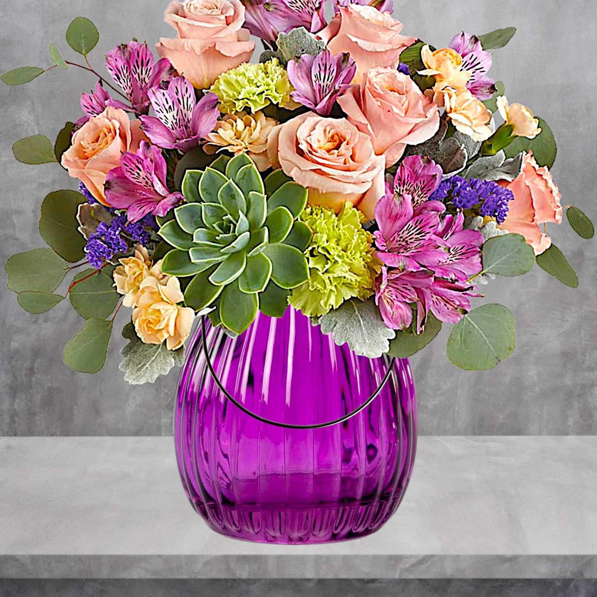 Bouquet of pink roses, purple alstroemeria, and succulents in a purple vase