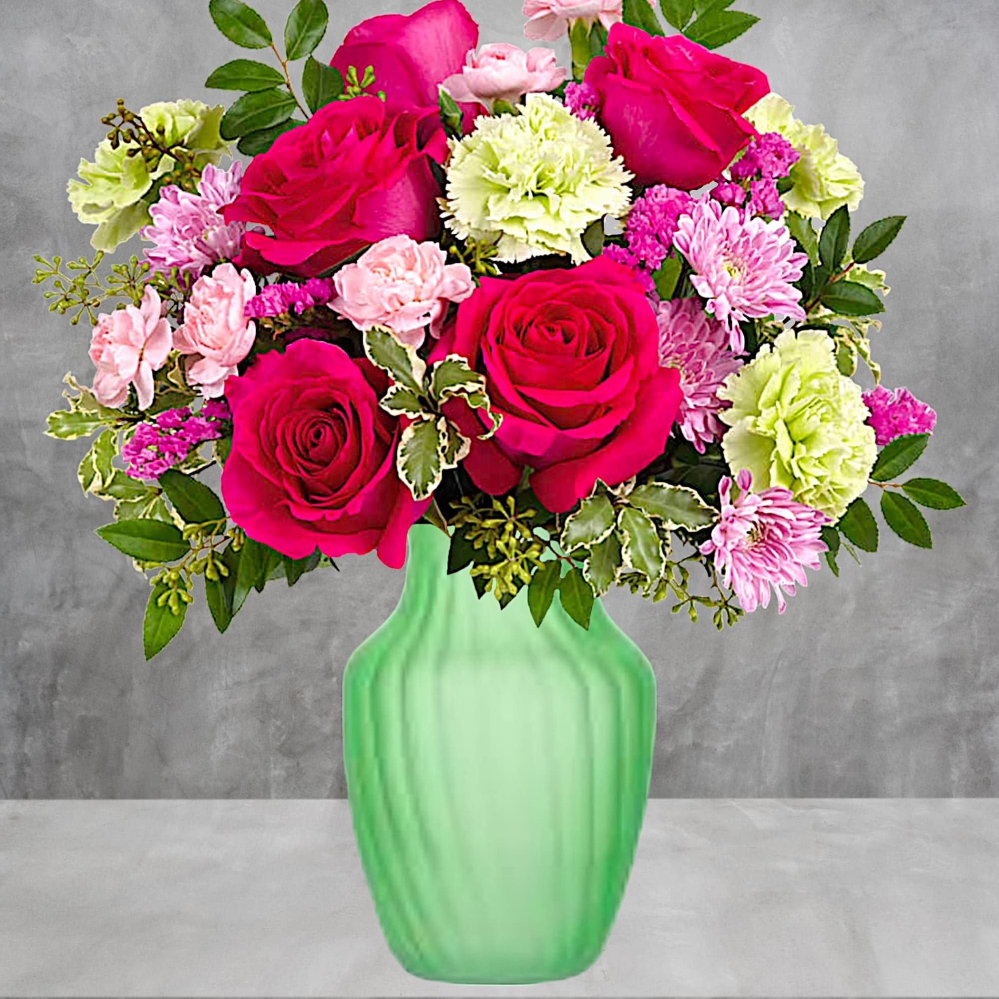 Pink roses and carnations in a green glass vase