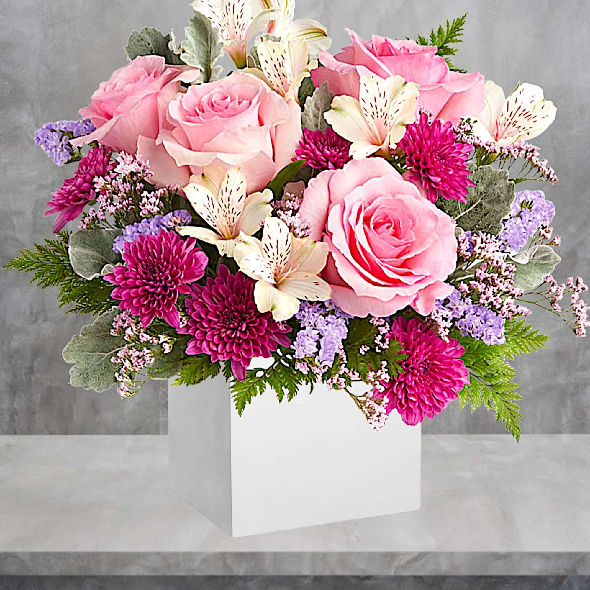 Pink roses and white lilies in a white box vase