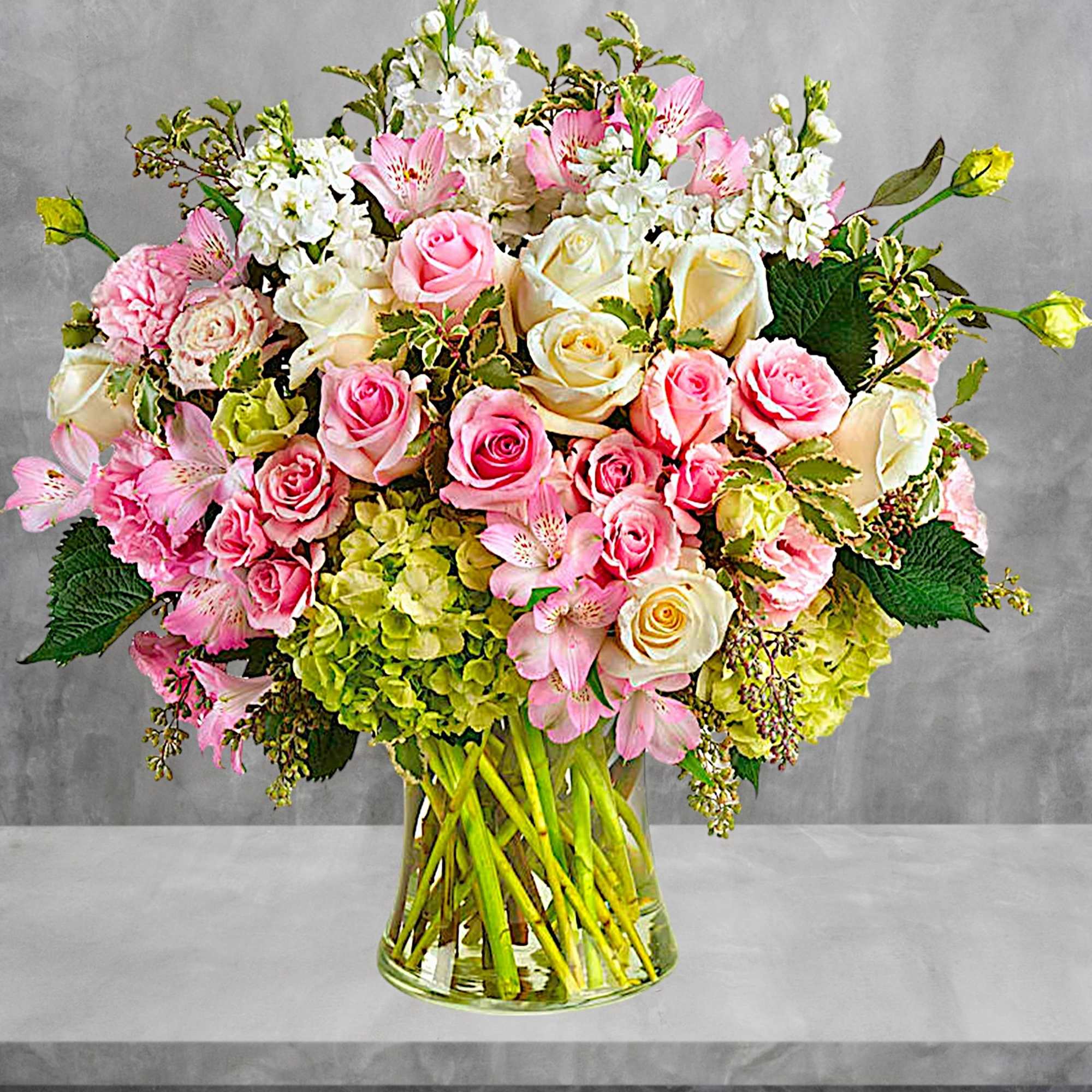 Pink and white rose bouquet with alstroemeria in a glass vase
