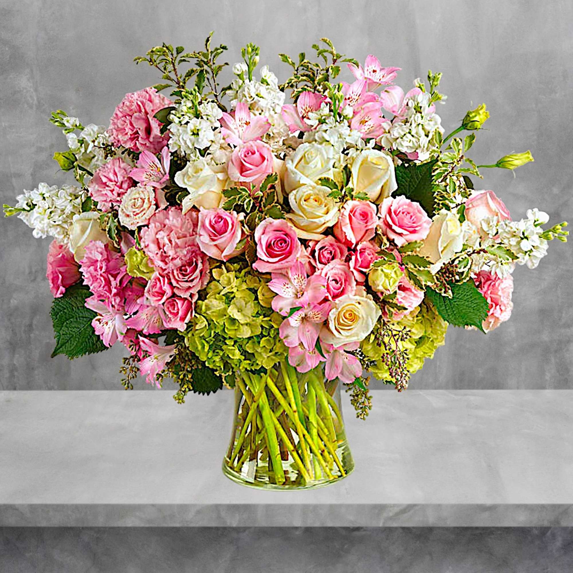 Large bouquet of pink and white roses with lilies in a glass vase