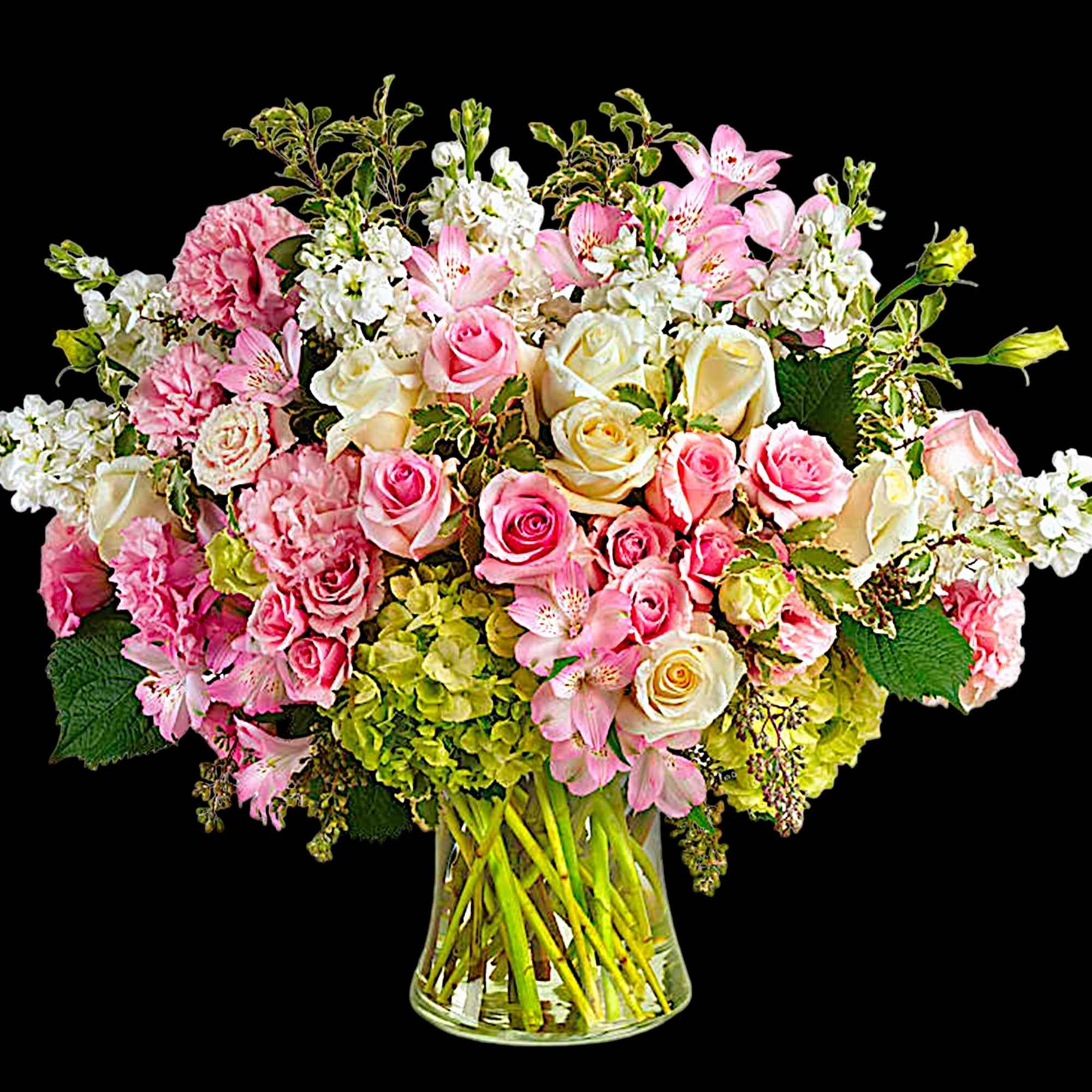 Pink and white roses with lilies and hydrangeas in a clear glass vase