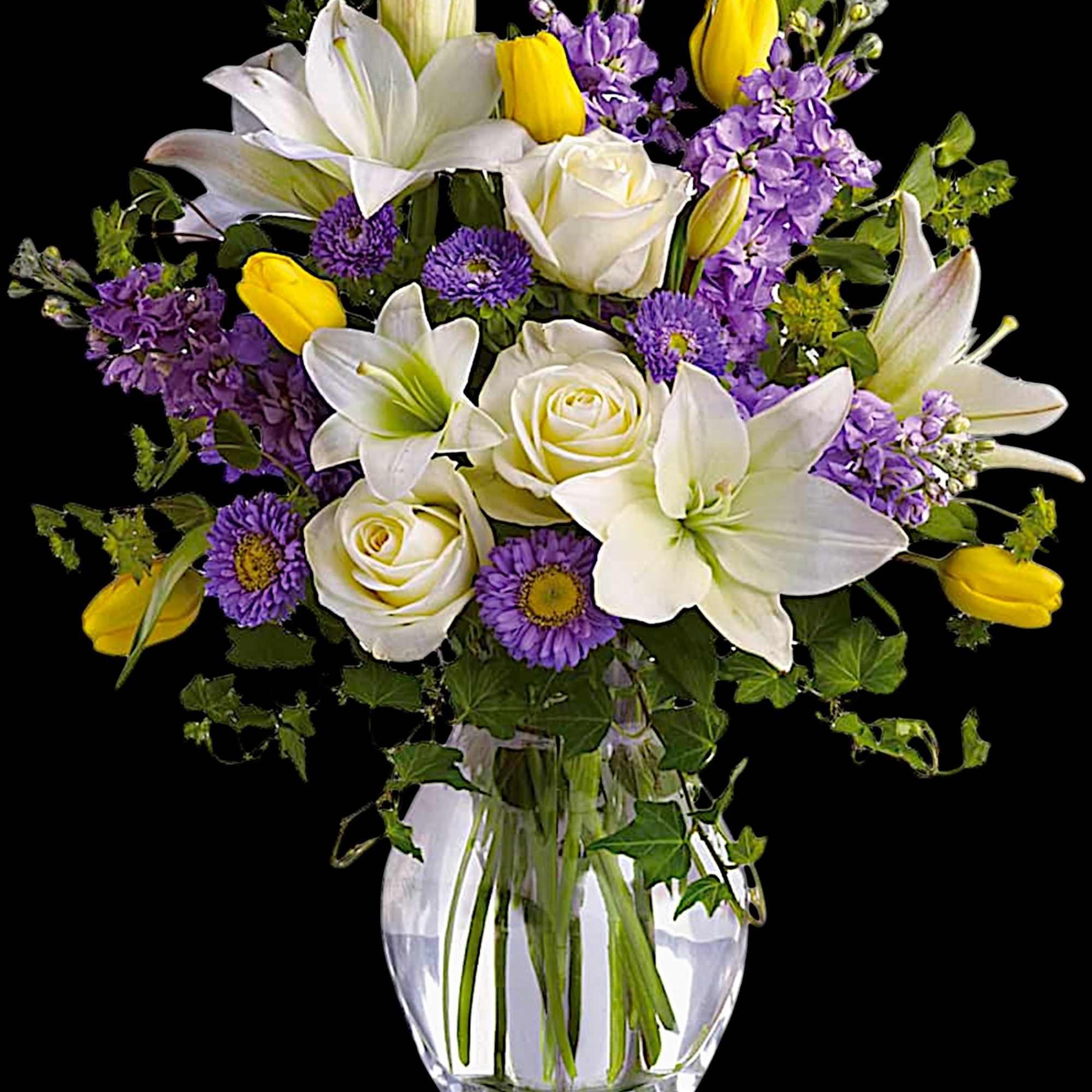 White lilies, roses, and purple flowers in a clear glass vase