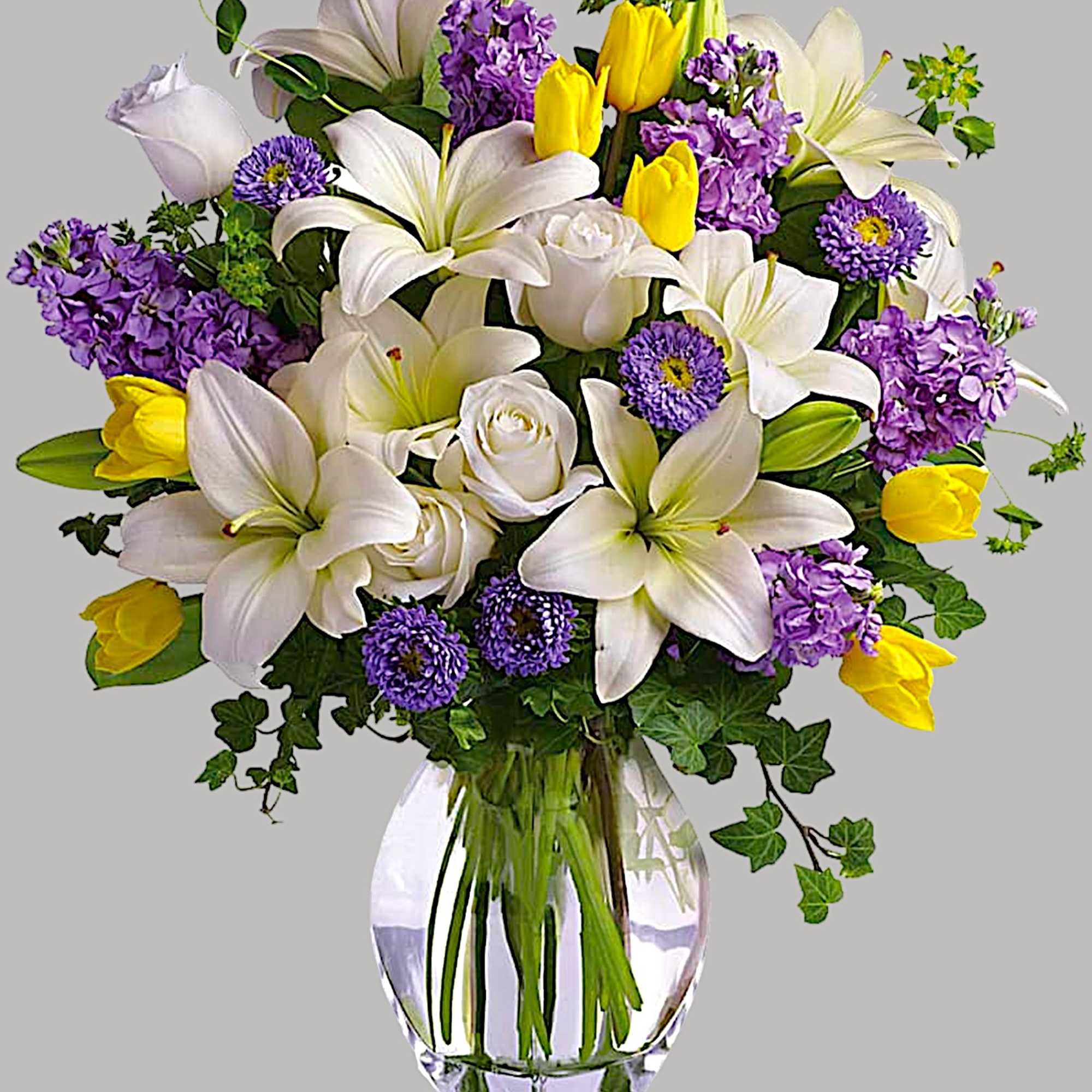 Bouquet of white lilies, purple flowers, and yellow tulips in a glass vase, photo 5 of 5