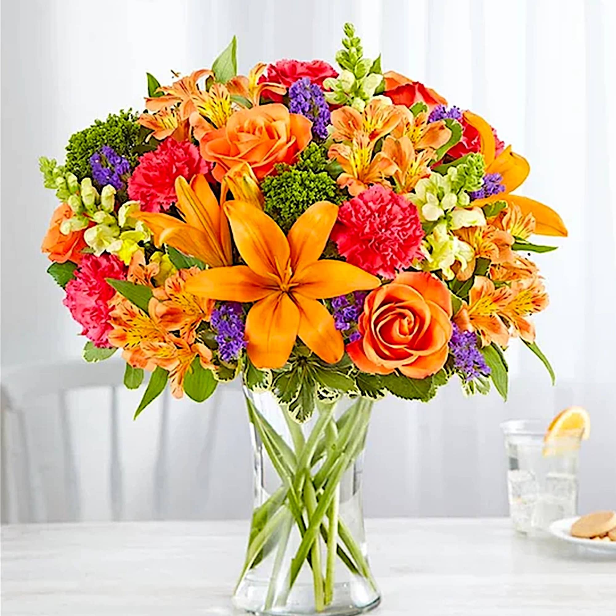 Orange and pink mixed bouquet in a clear glass vase, photo 2 of 5