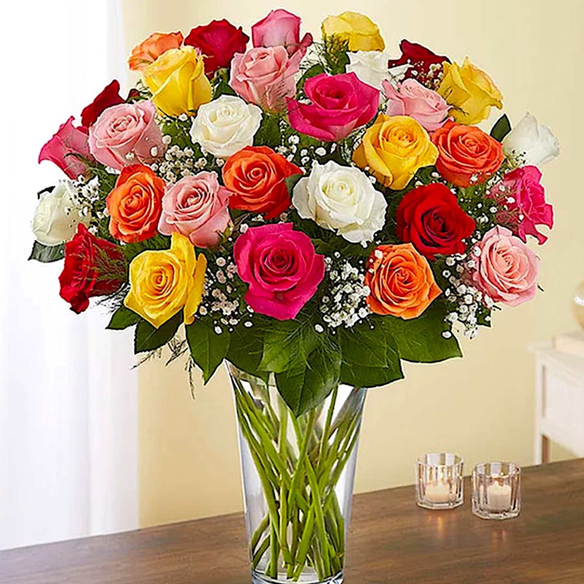 Mixed roses in a clear glass vase on a table