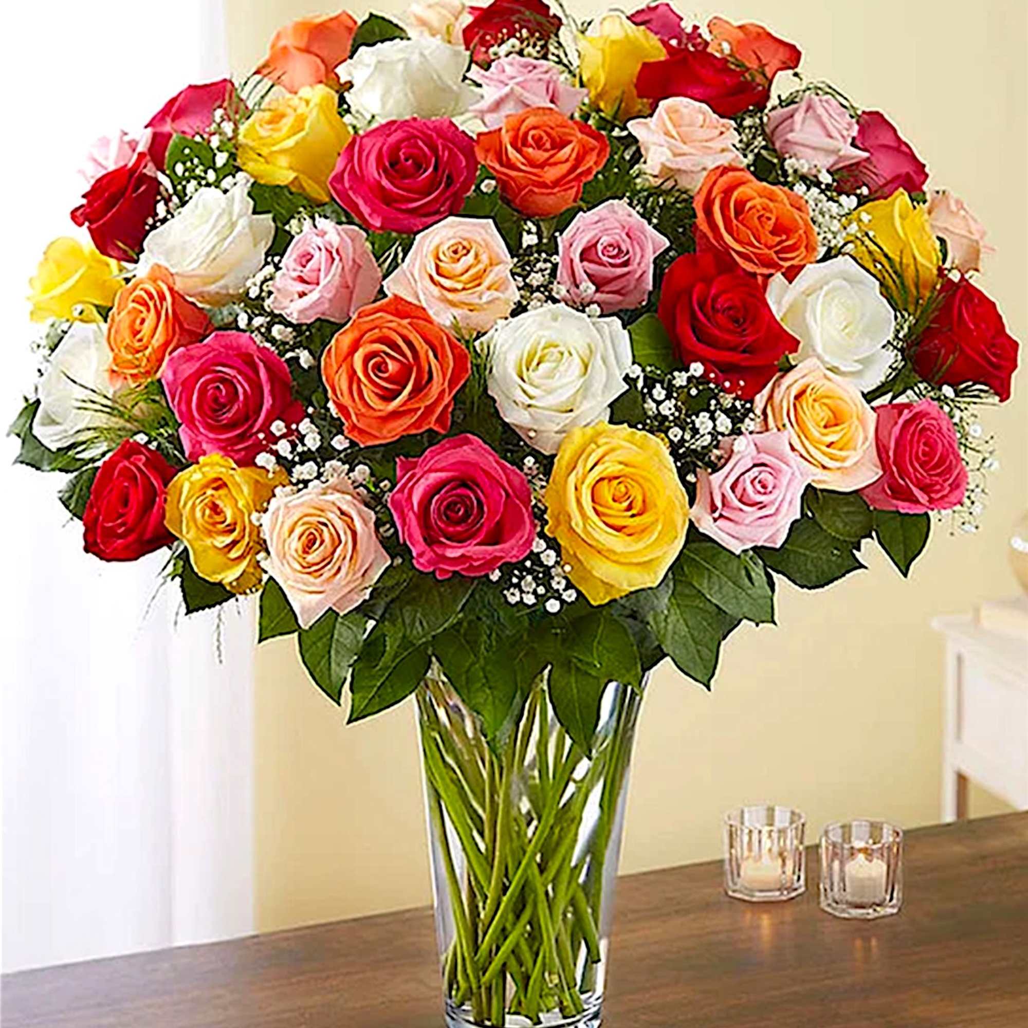 Mixed roses in a clear glass vase with baby’s breath