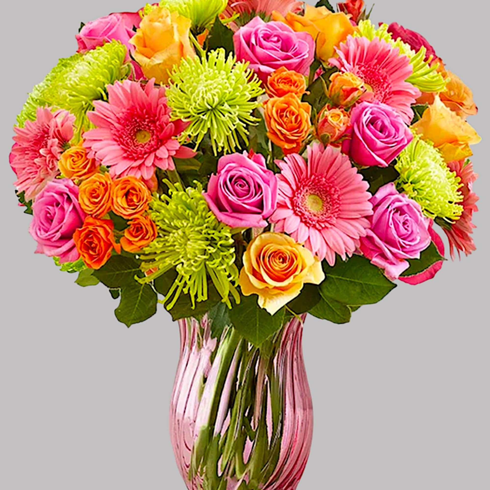 Bouquet of pink and orange roses with pink gerbera daisies in a glass vase