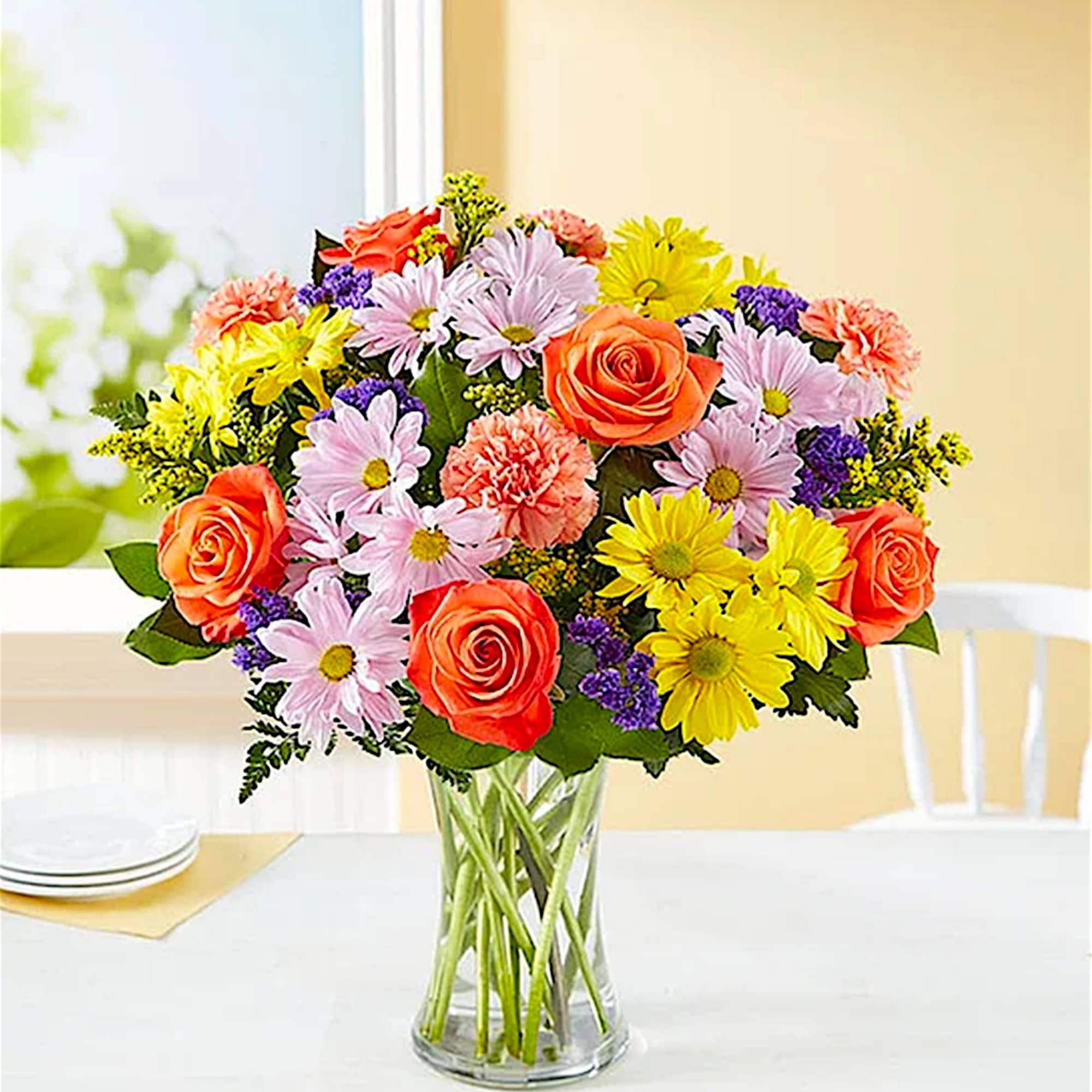 Mixed bouquet of roses, daisies, and carnations in a clear glass vase, photo 2 of 5