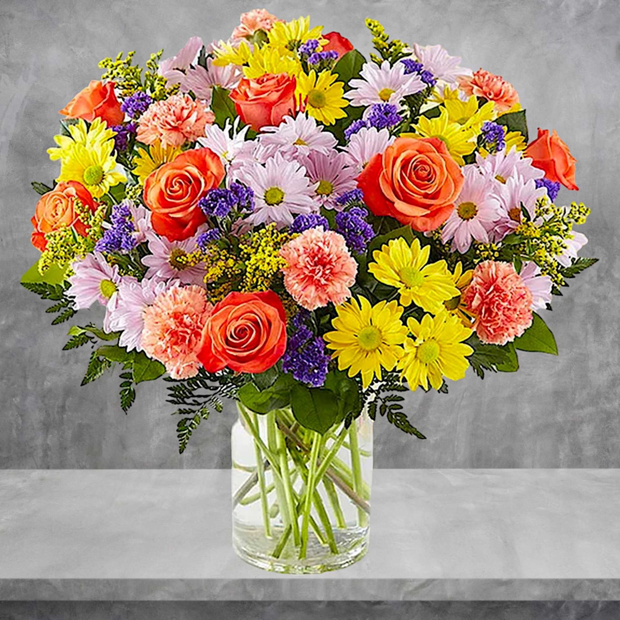 Mixed bouquet of roses, daisies, and carnations in a clear glass vase, photo 3 of 5