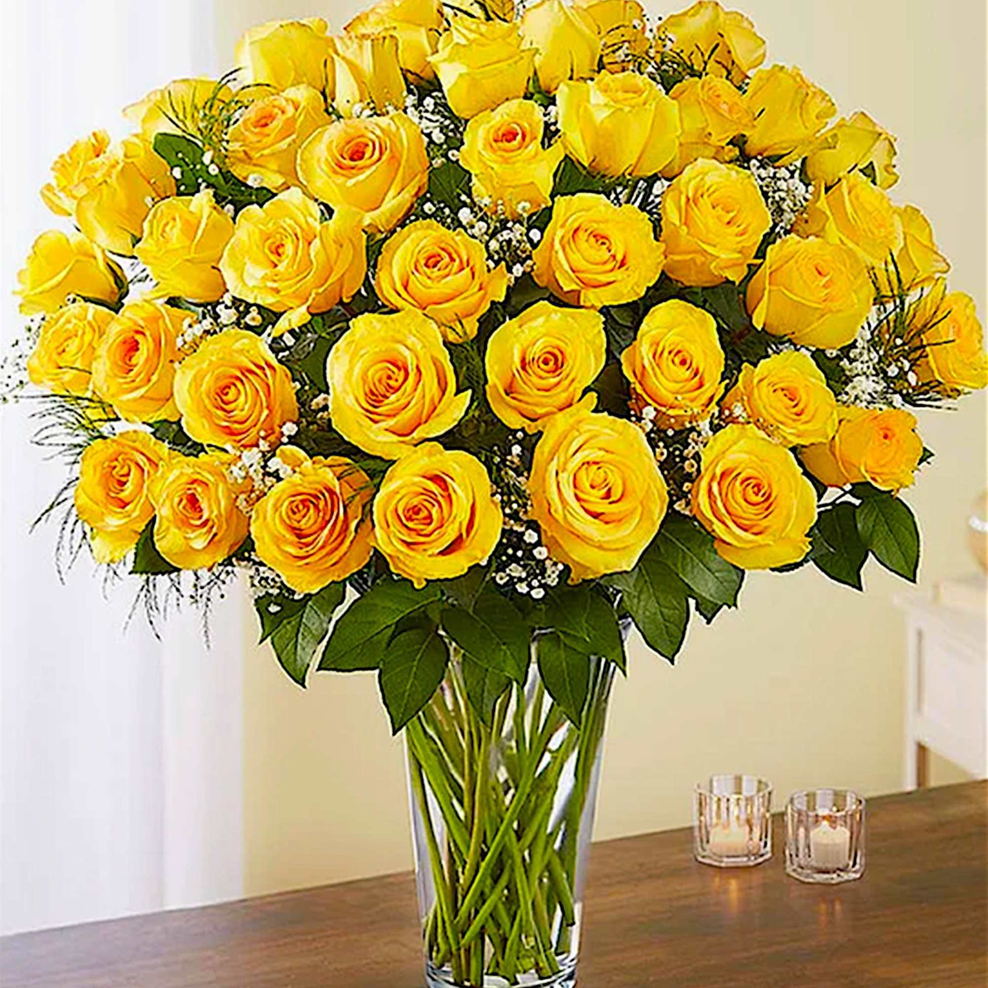 Large bouquet of yellow roses in a clear glass vase