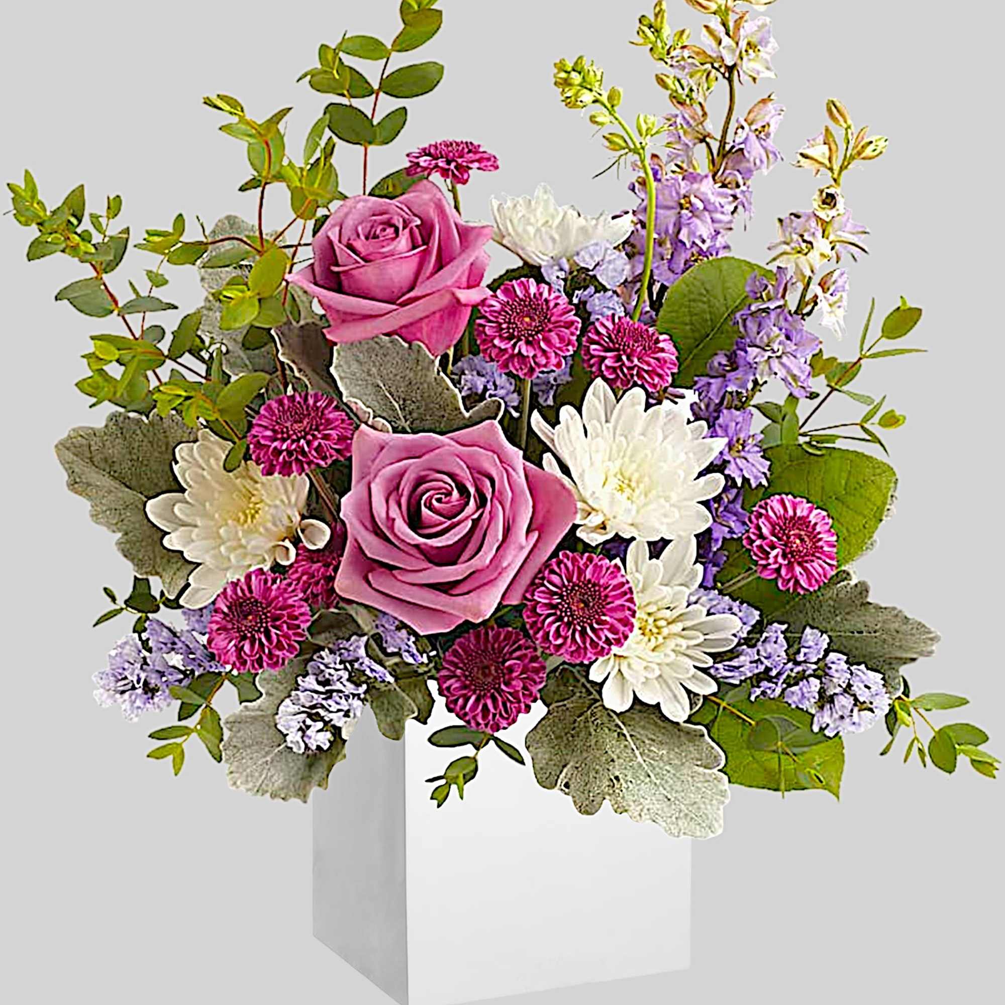 Pink roses with white and purple flowers in a white box vase