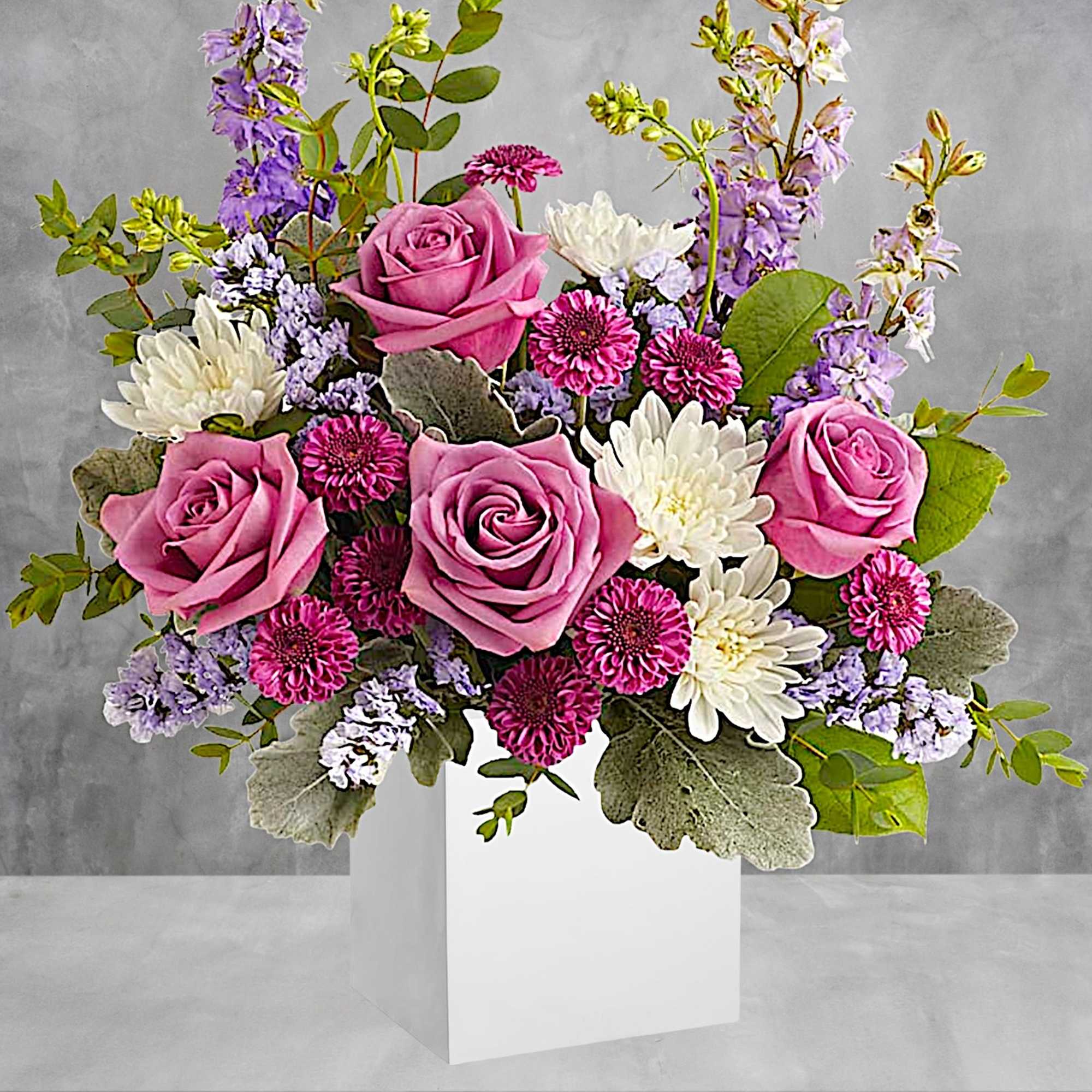 Pink roses and white daisies in a white vase