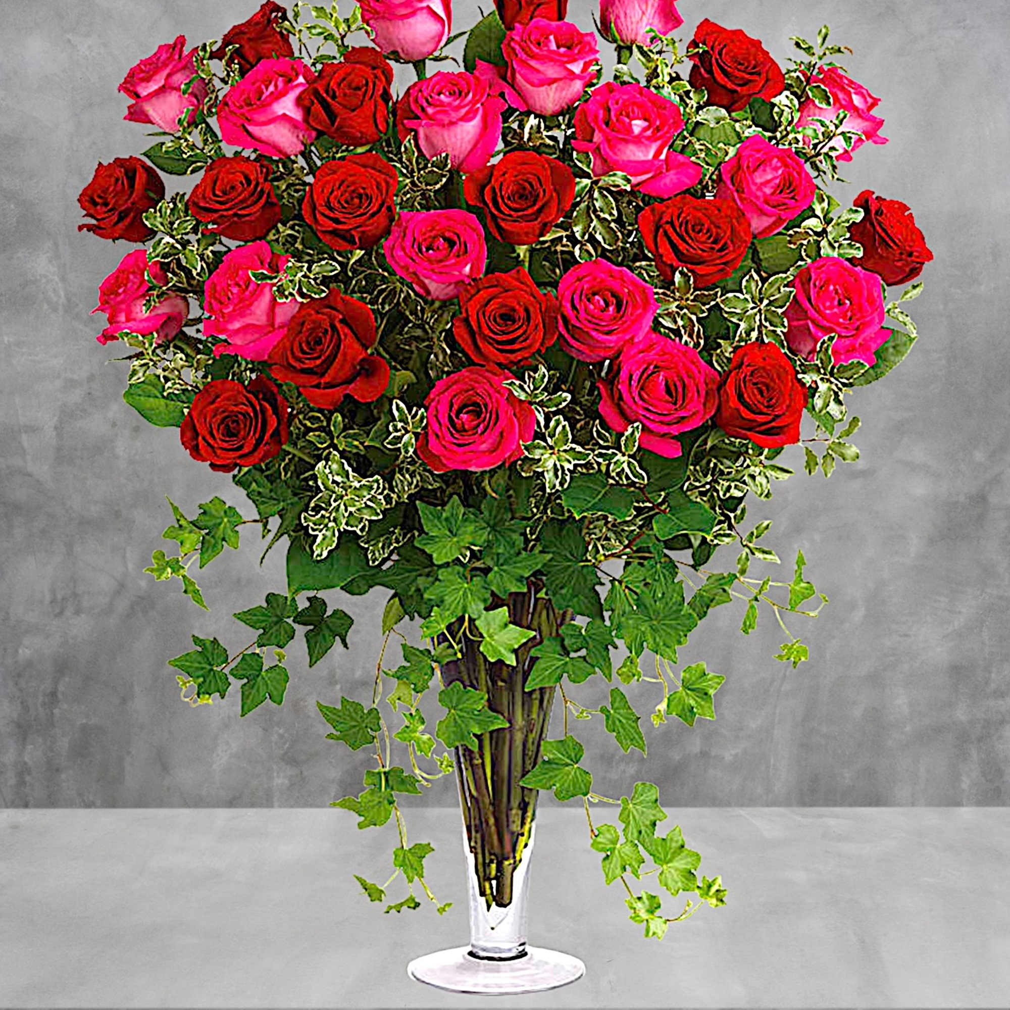 Tall bouquet of red and pink roses in a clear glass vase, photo 2 of 4