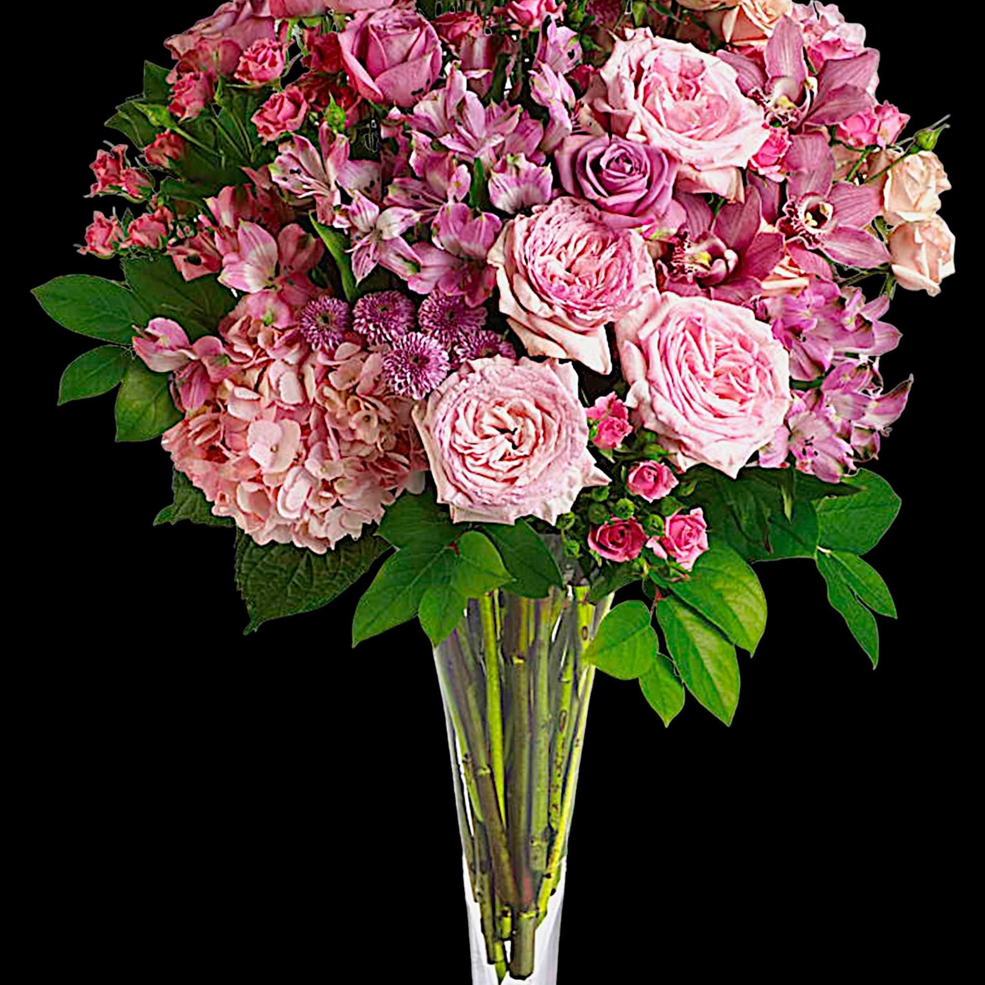 Pink roses and mixed blooms arranged in a tall clear vase