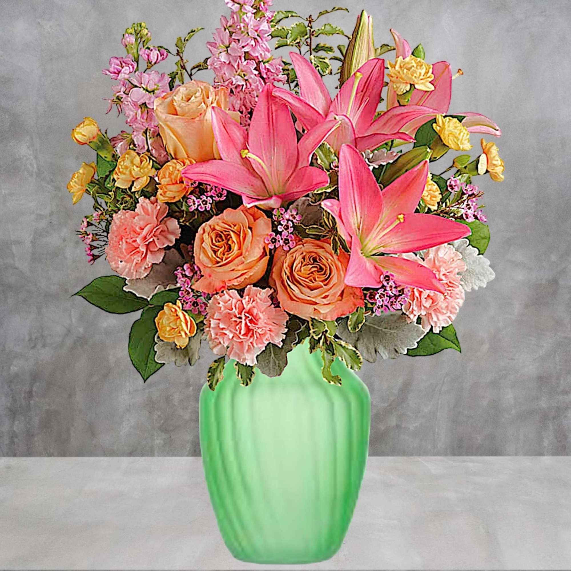 Pink lilies and peach roses arranged in a green vase