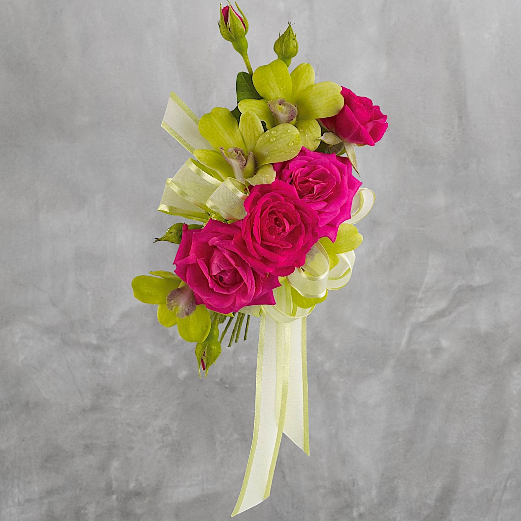 Pink roses and green orchids arranged with ribbon streamers