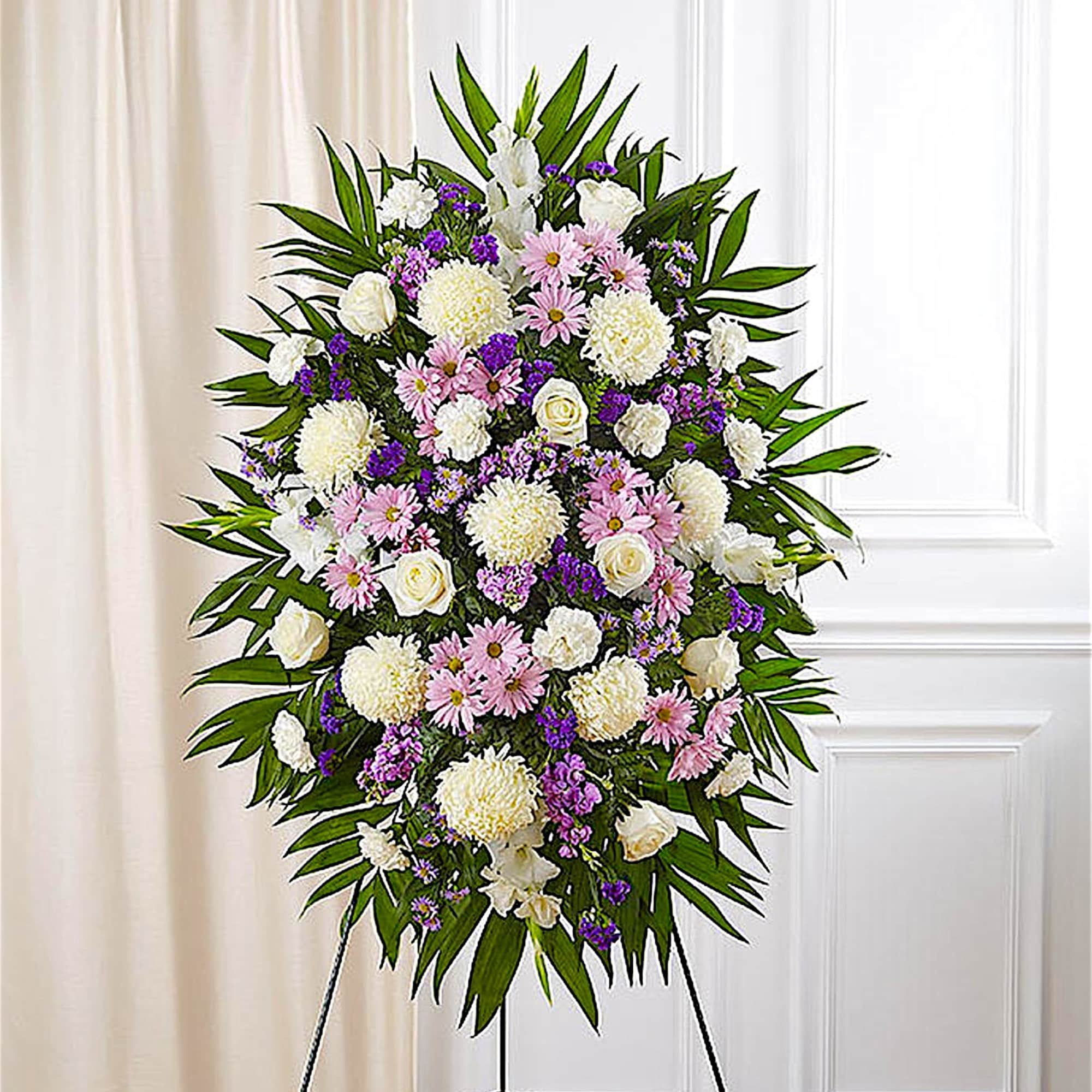 Standing floral wreath of white, pink, and purple flowers on an easel
