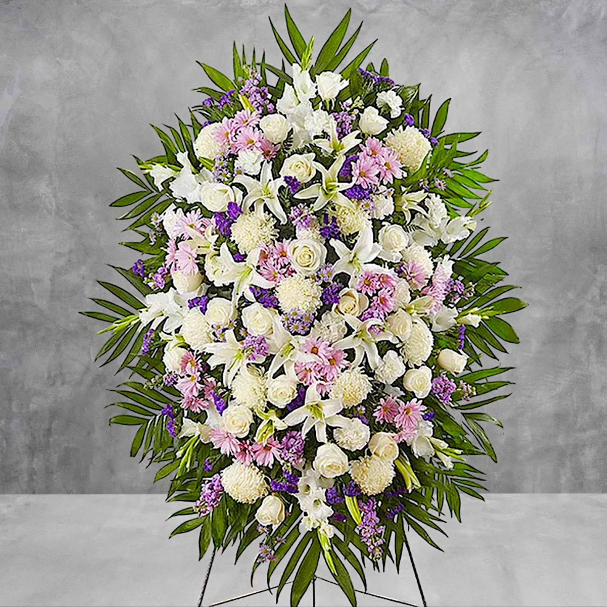 Standing funeral spray of white, pink, and purple flowers