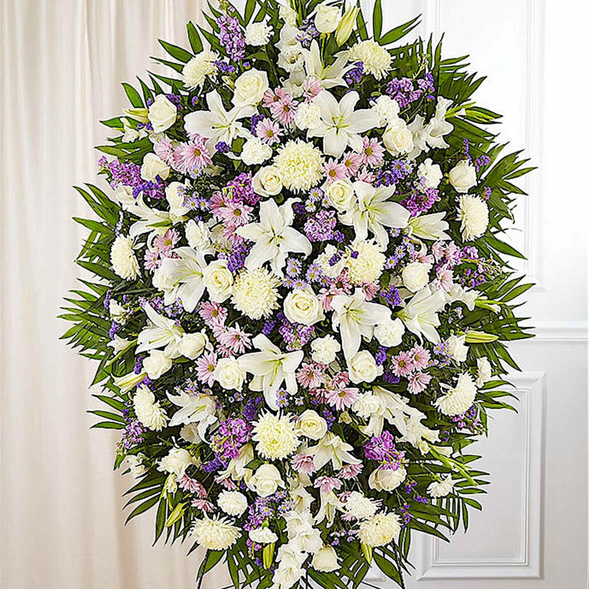 Large white and purple funeral spray on a stand