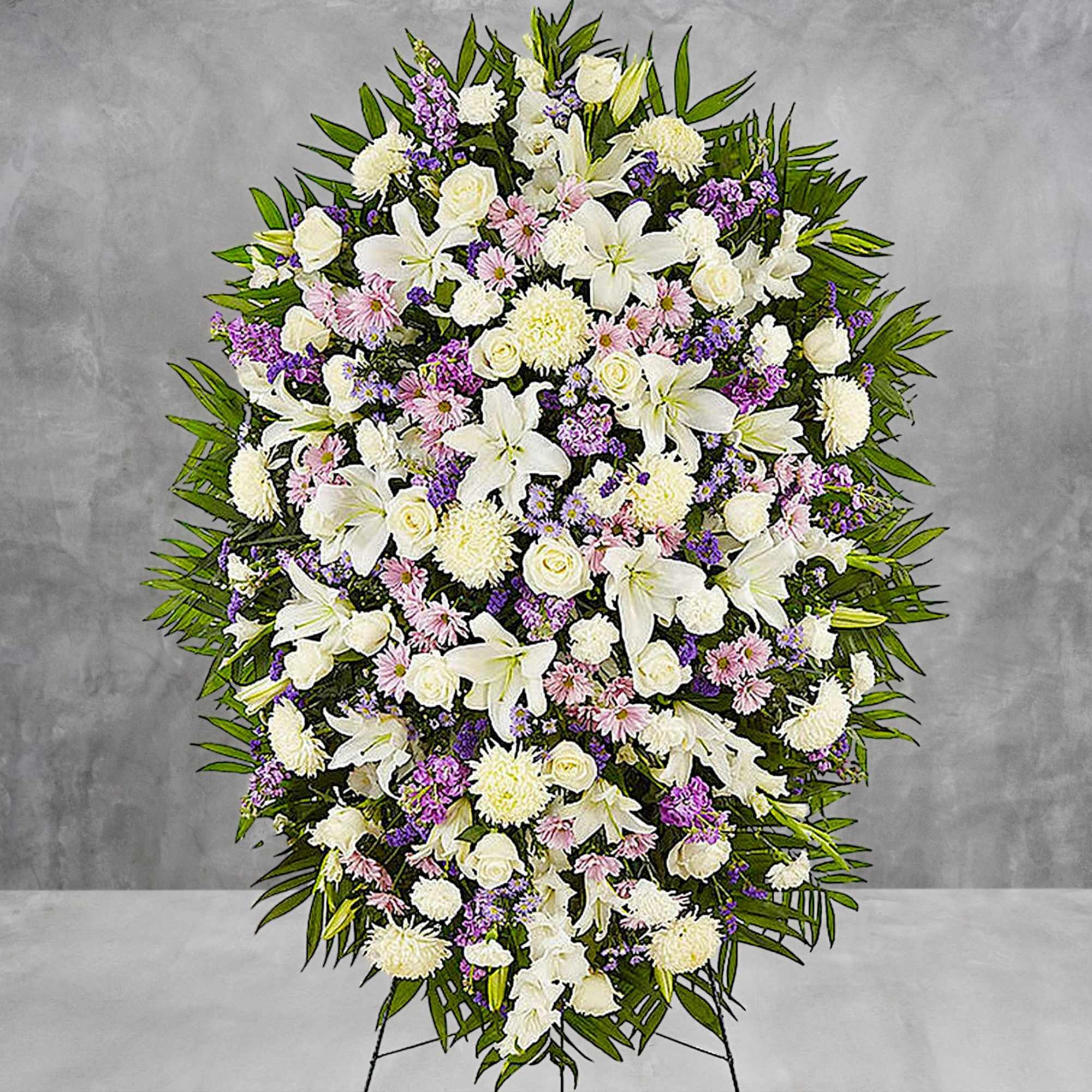 Large standing spray of white and lavender flowers on a gray background