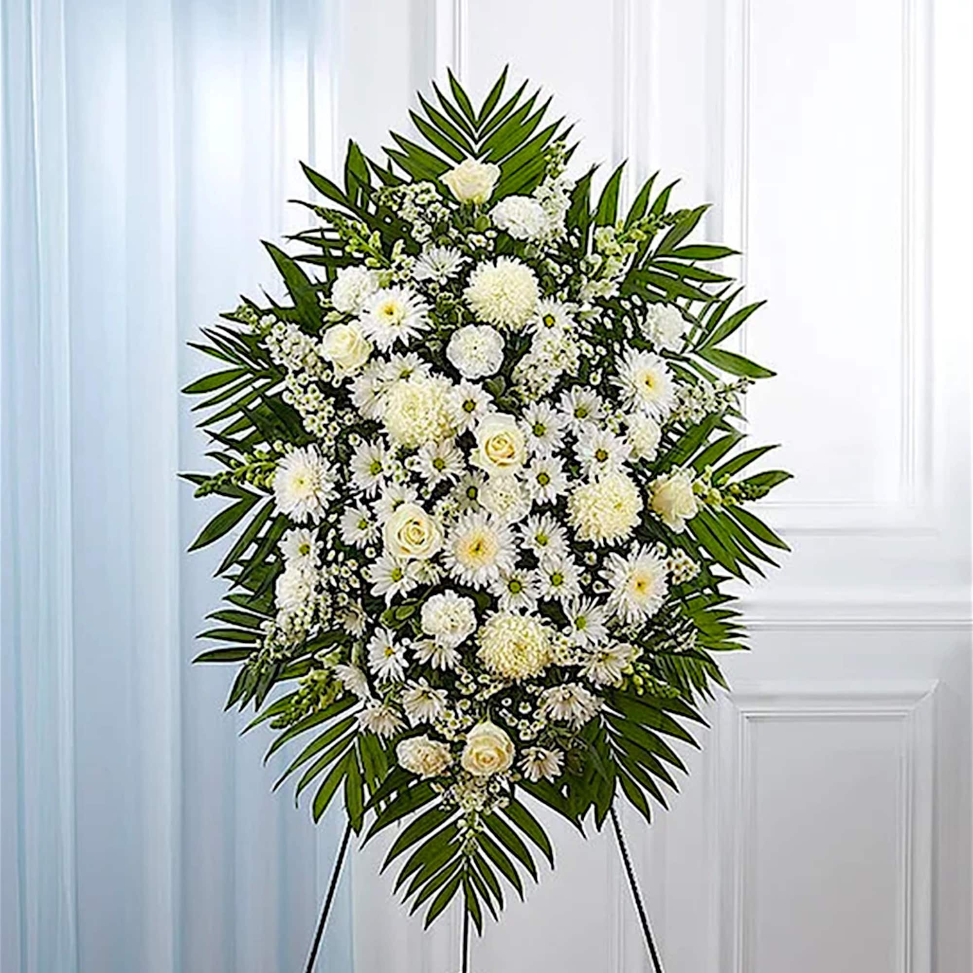 White funeral spray with daisies and roses on a stand
