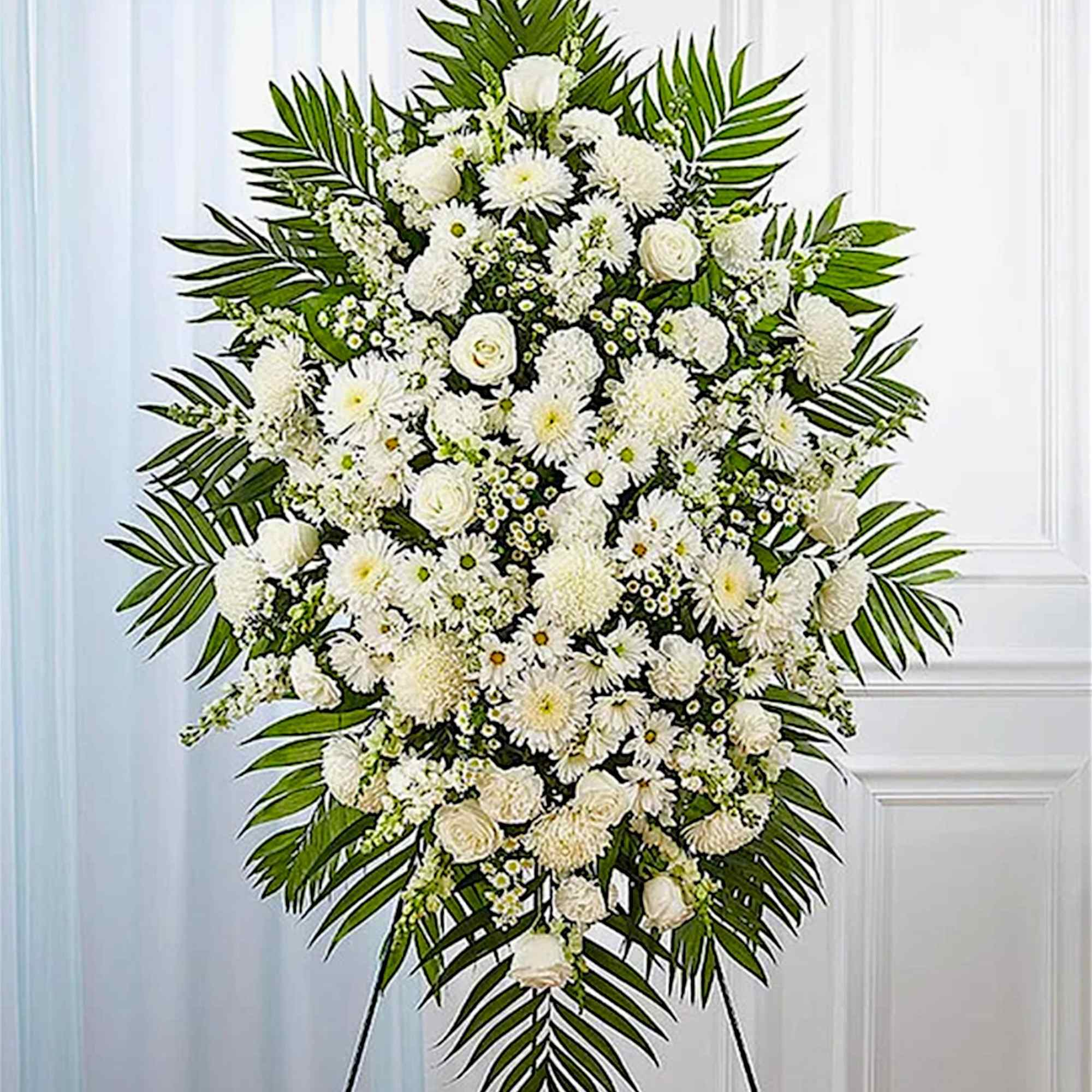 White funeral spray with roses and daisies on a standing easel