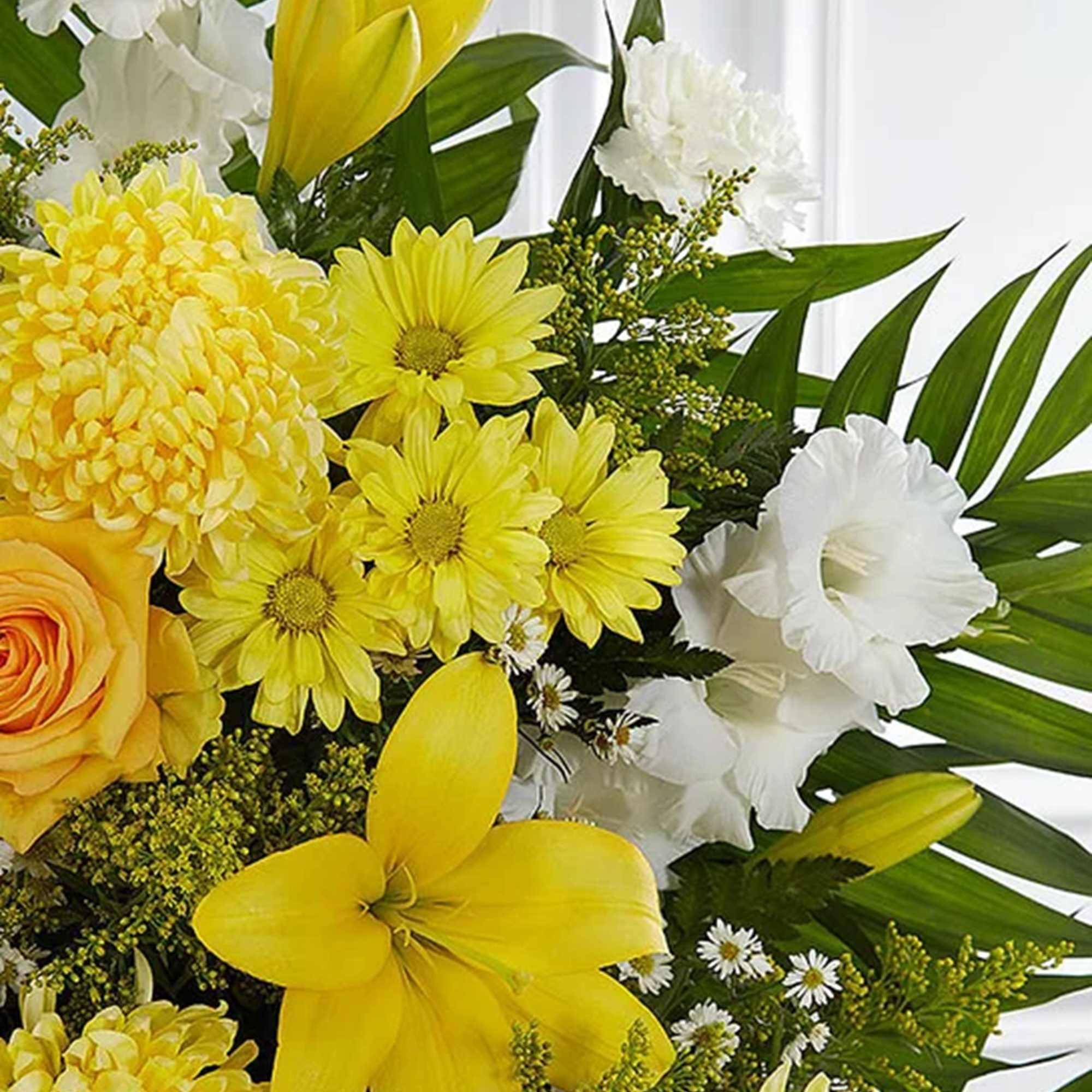 Yellow and white floral bouquet with lilies, daisies, and roses