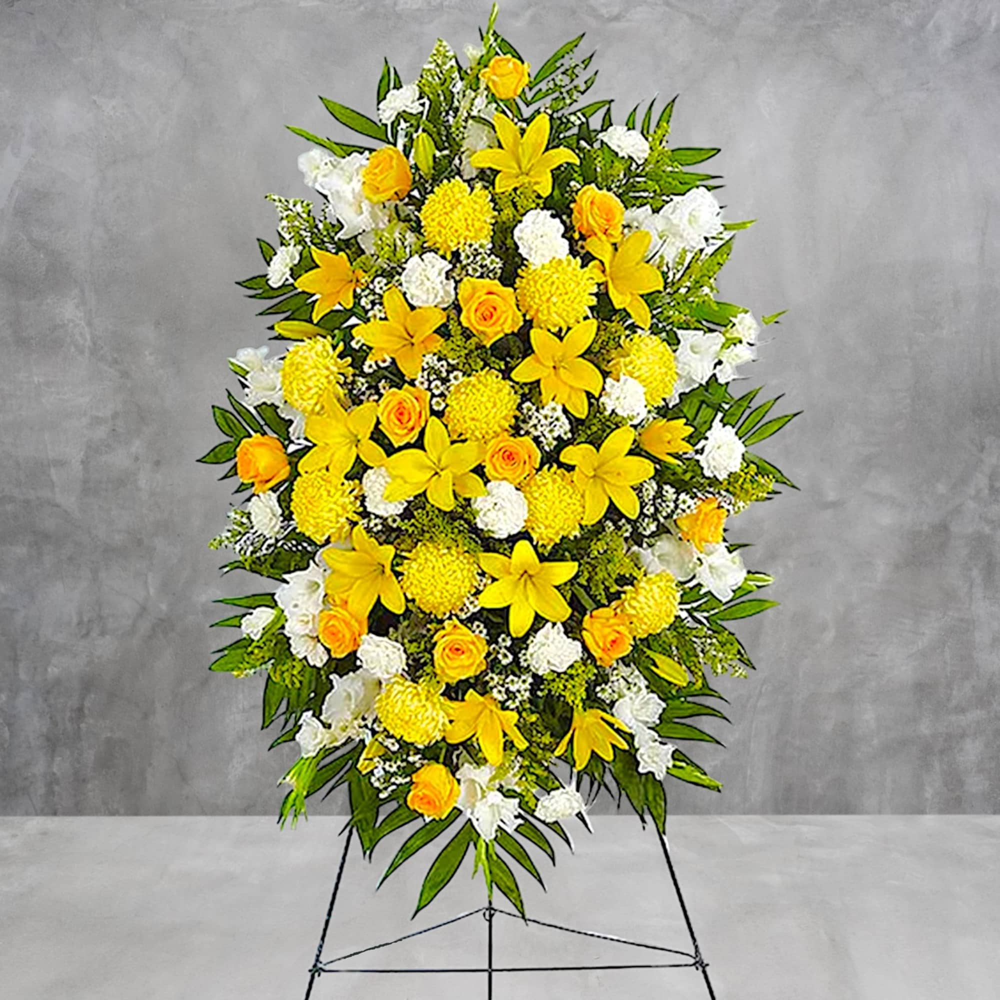 Standing floral spray with yellow and white flowers on an easel