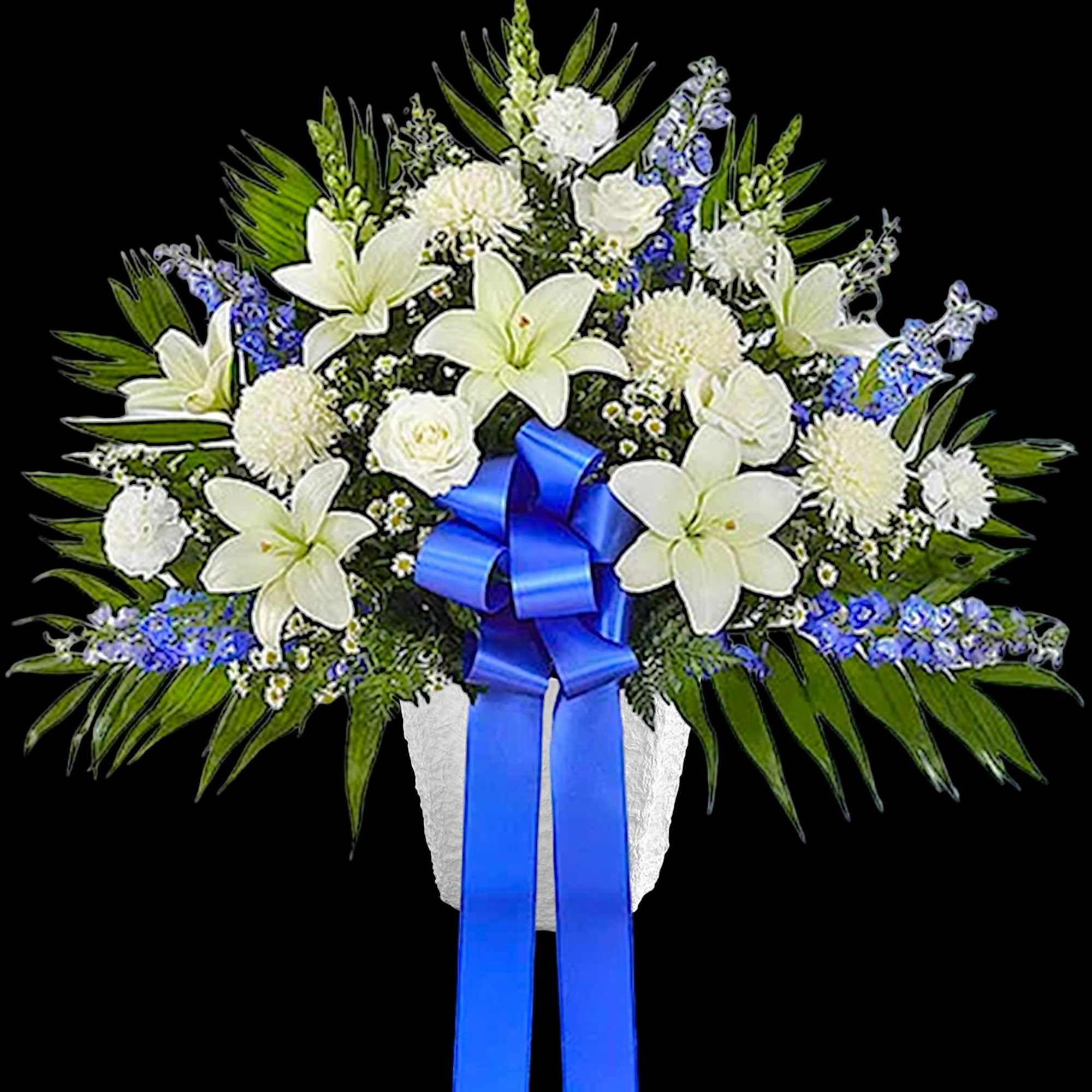 White lilies and blue flowers in a white vase with a blue ribbon