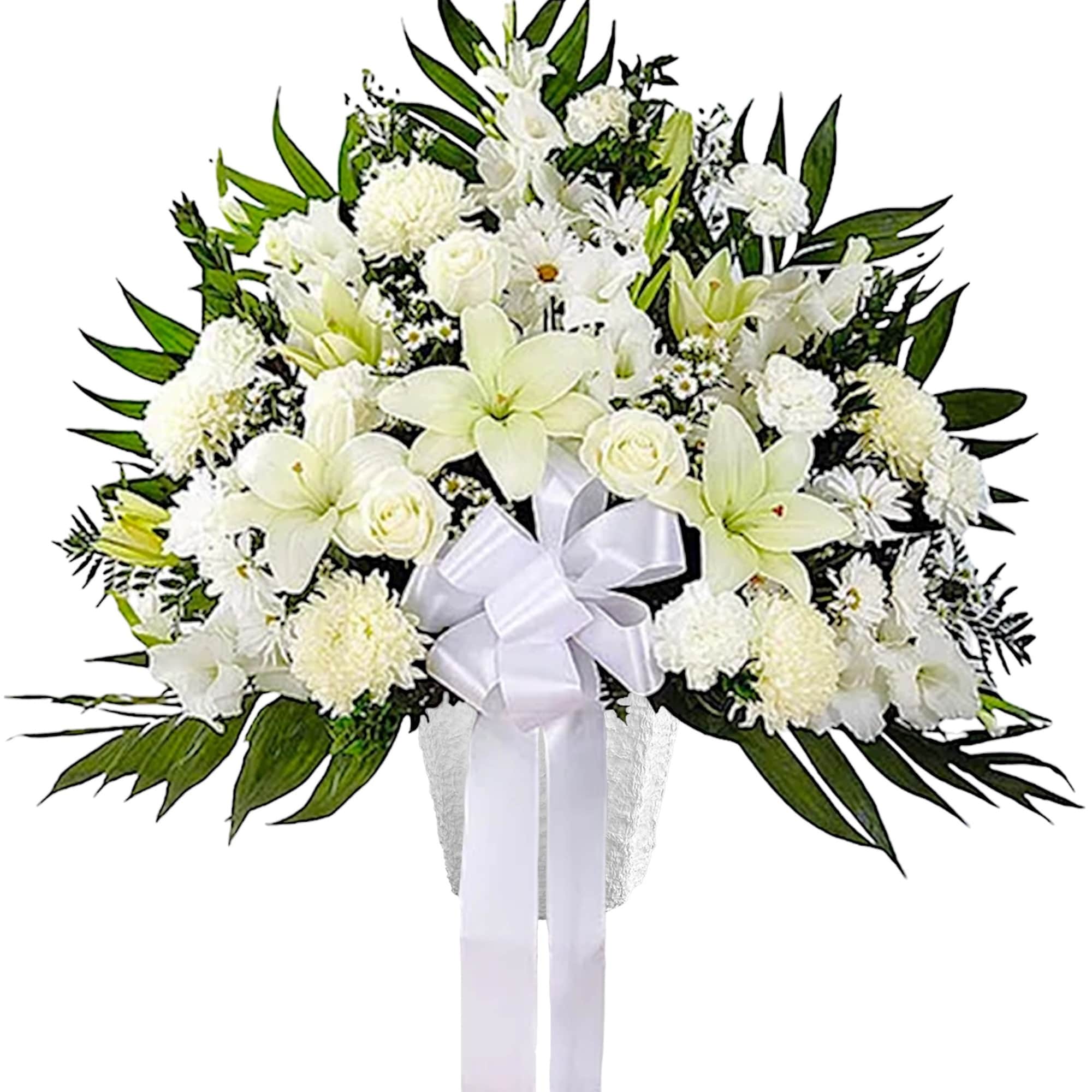 White funeral spray with lilies, roses, and a ribbon on a stand