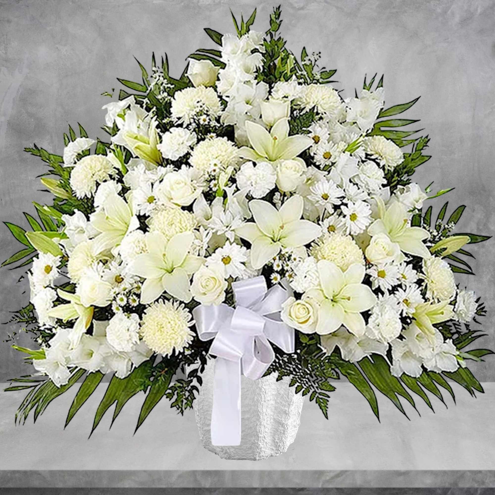 Large white floral arrangement in a vase with a white ribbon