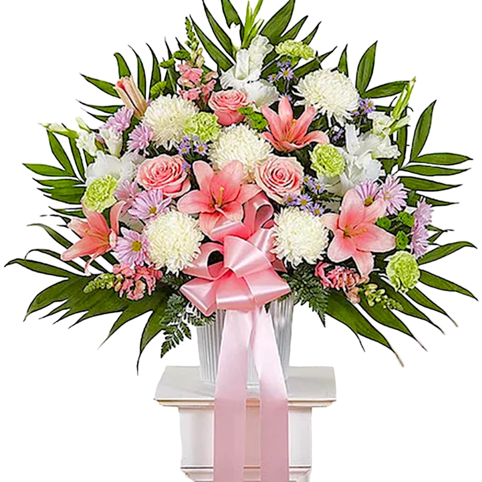 Pink and white floral spray in a vase with a pink ribbon