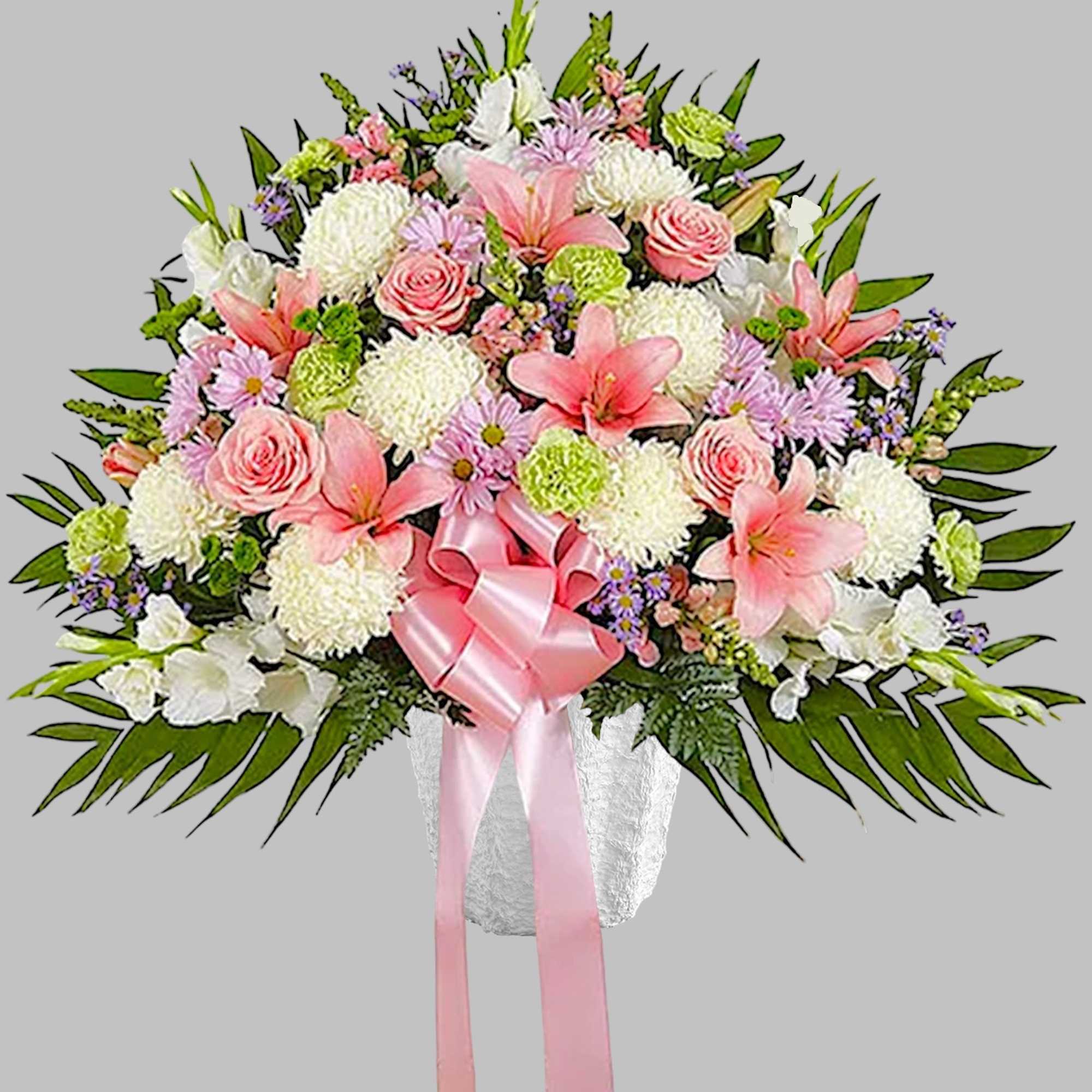 Pink and white floral spray with a pink ribbon in a white vase