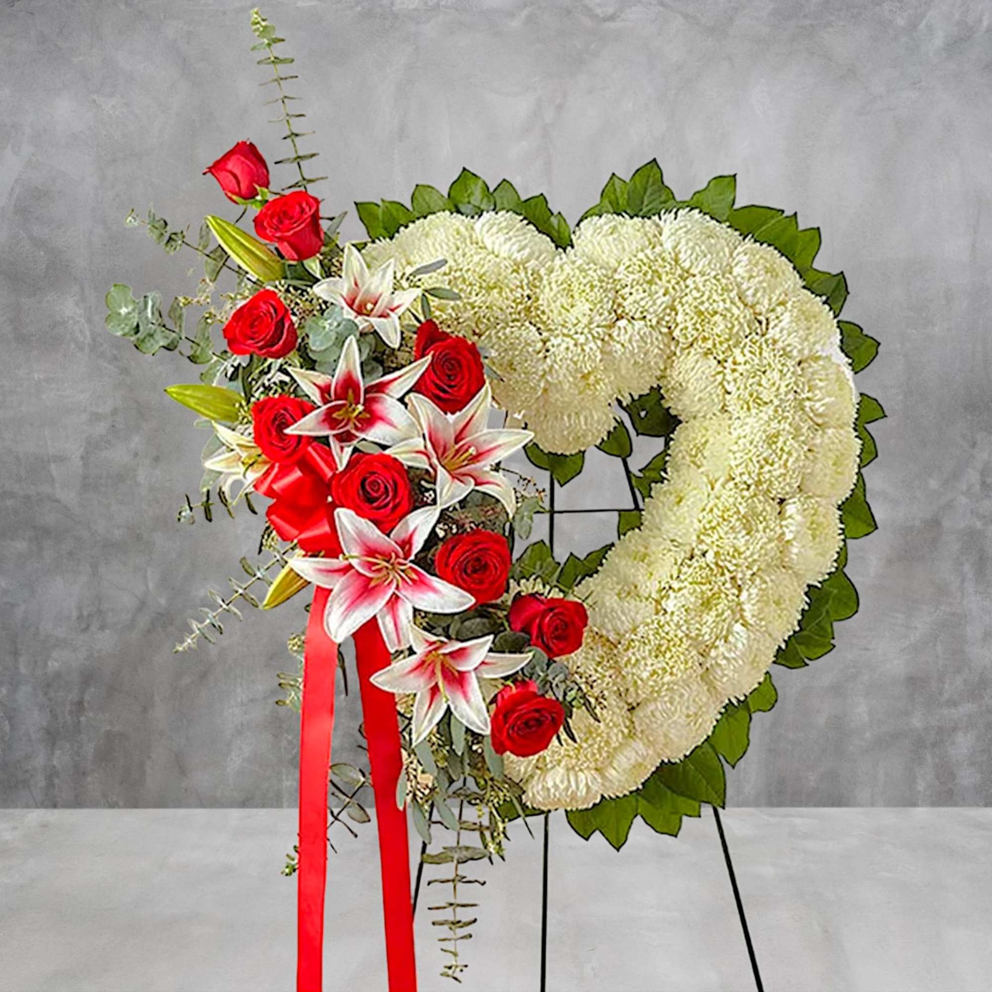 Heart-shaped floral wreath with white chrysanthemums and red roses