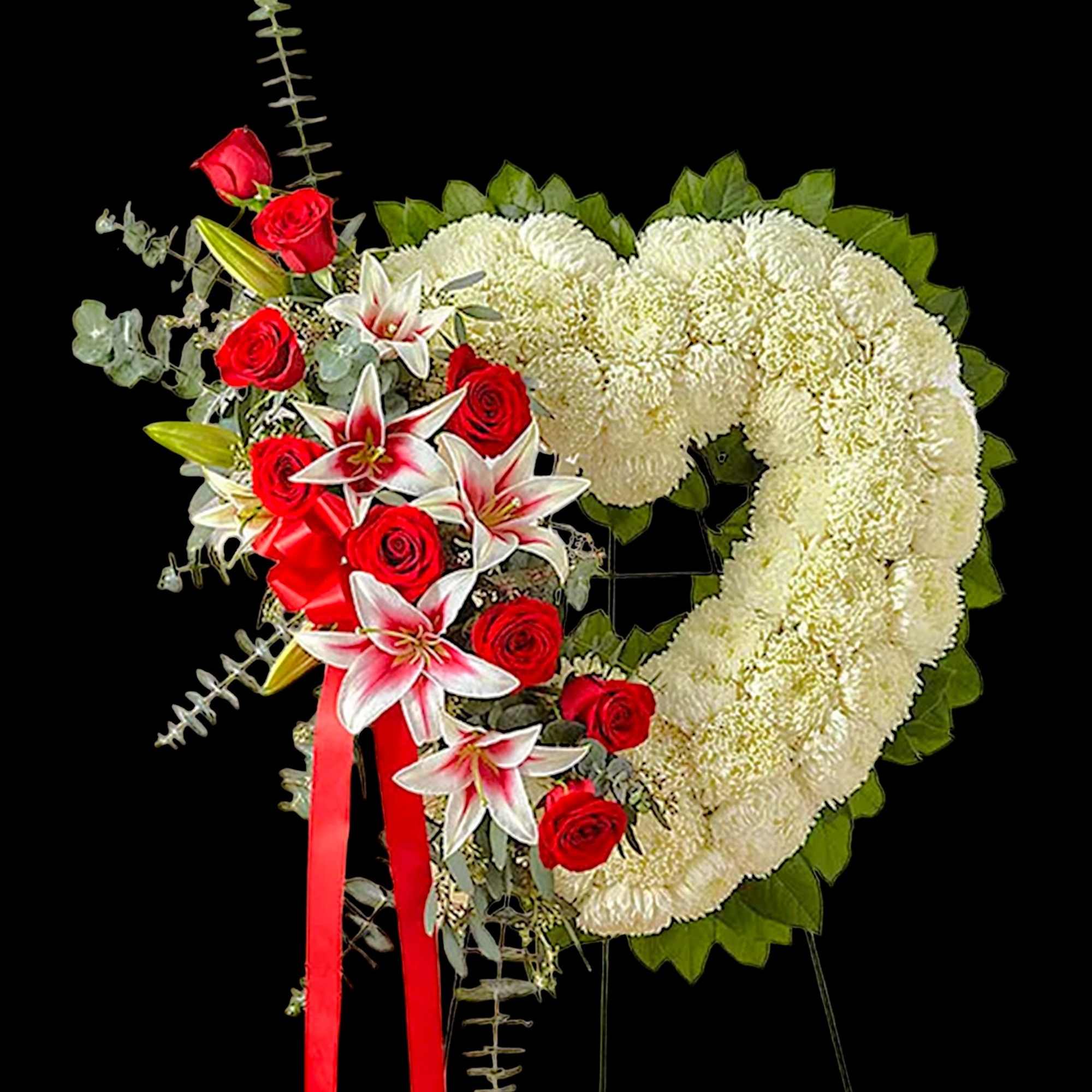 Heart-shaped white floral wreath with red roses and lilies