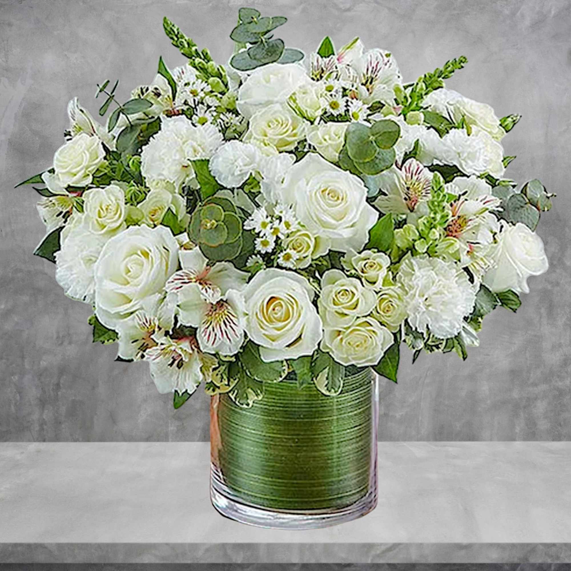 White roses and mixed white flowers in a glass vase