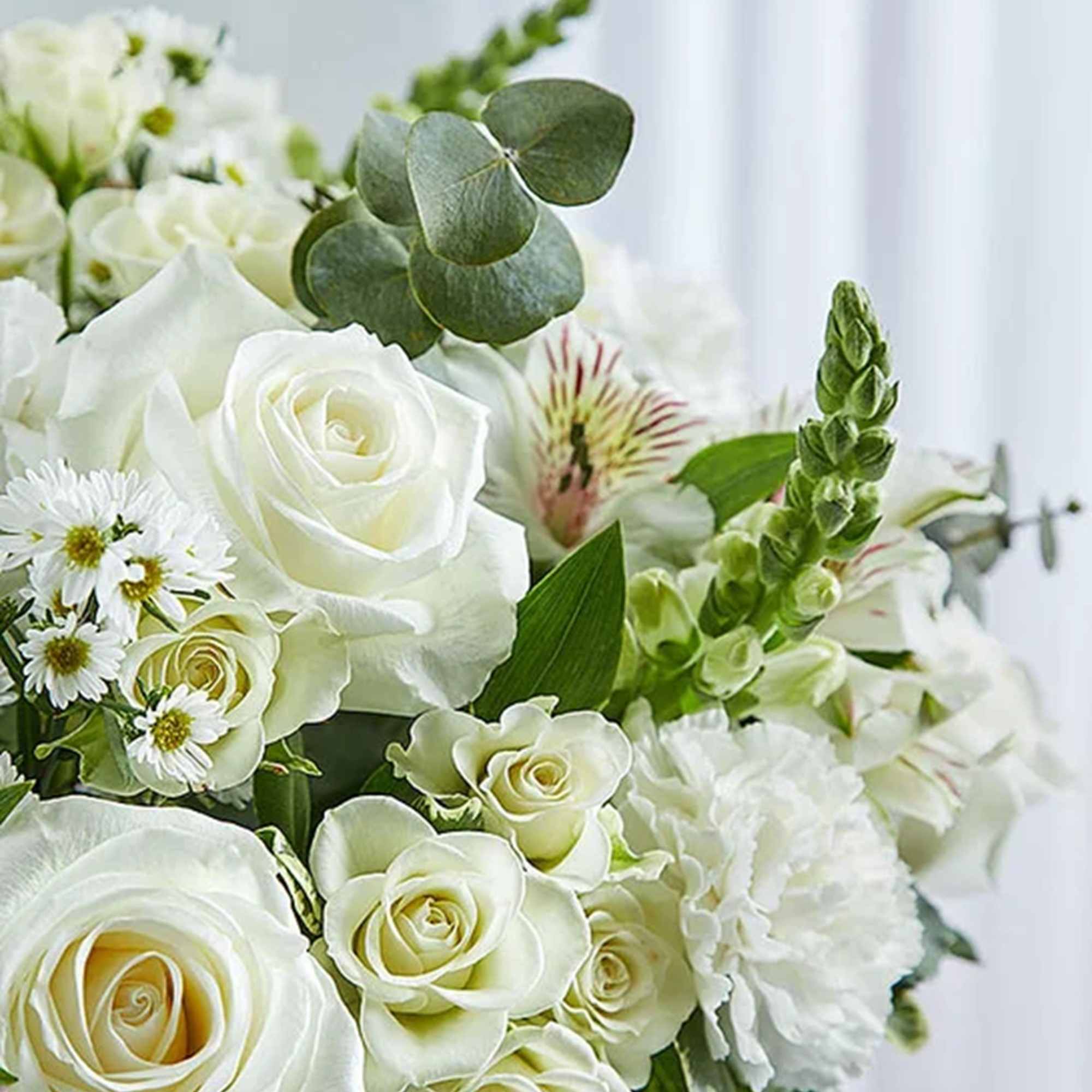 White rose bouquet with small white filler flowers and green eucalyptus