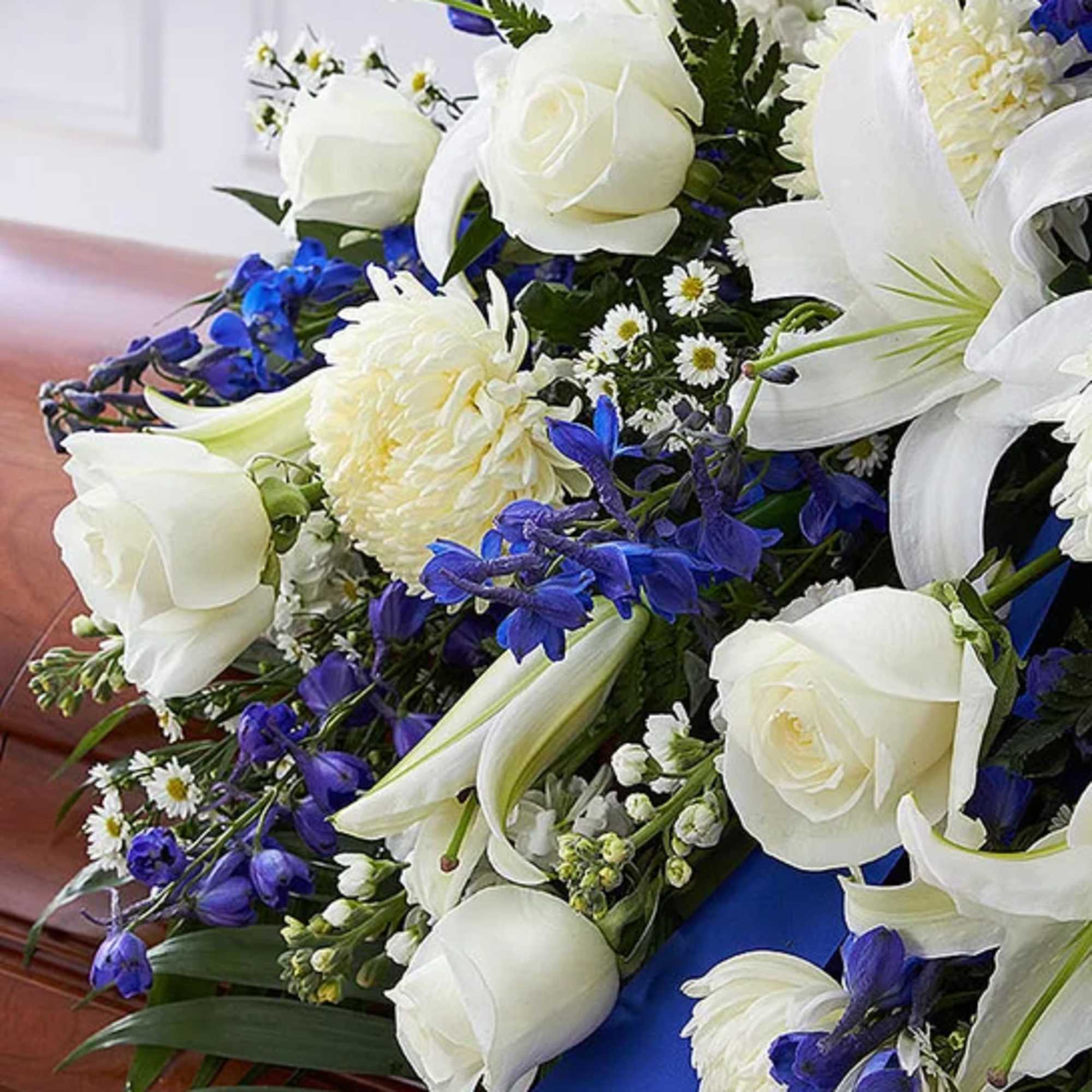 White roses and lilies with blue flowers in a bouquet