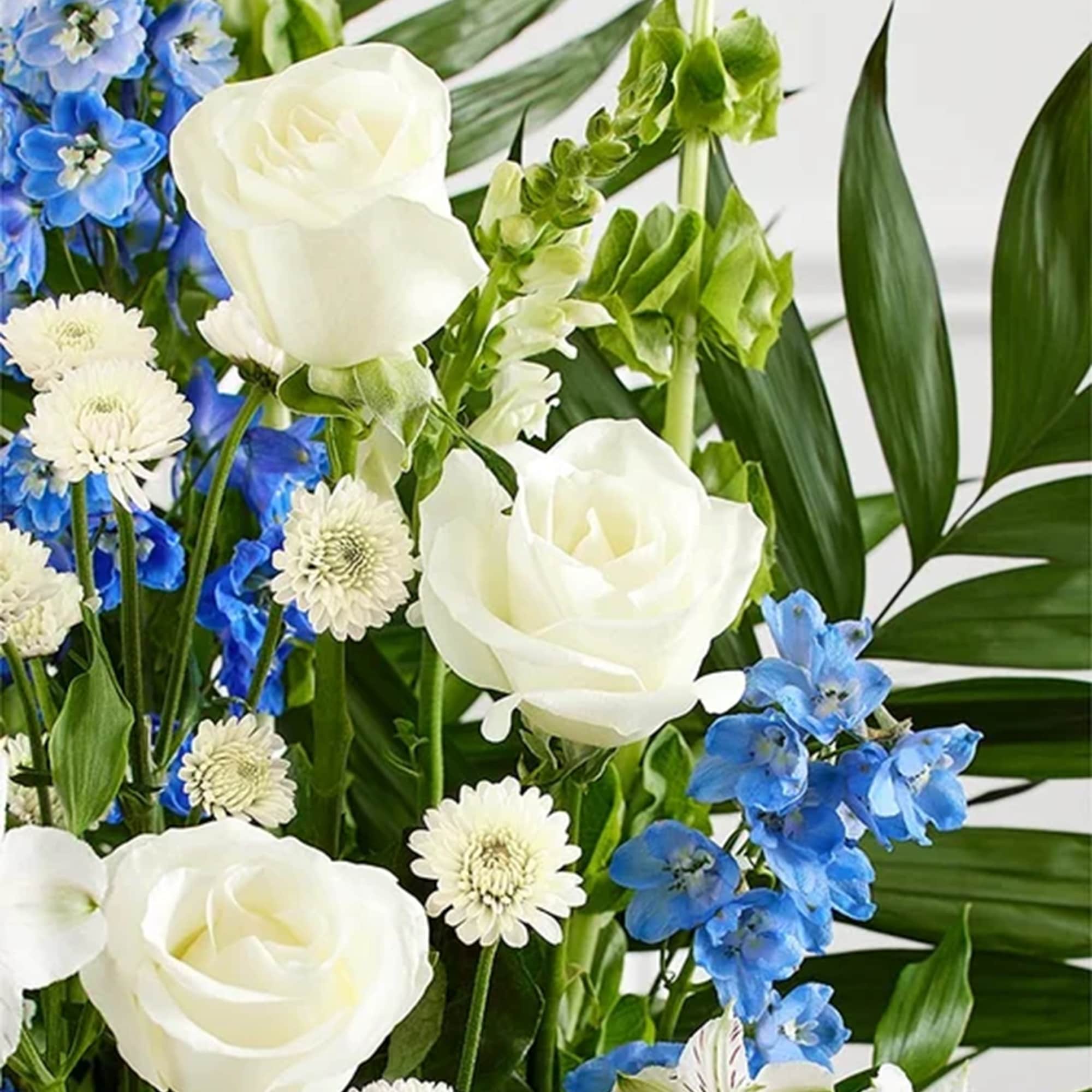 Bouquet of white roses, blue flowers, and white daisies