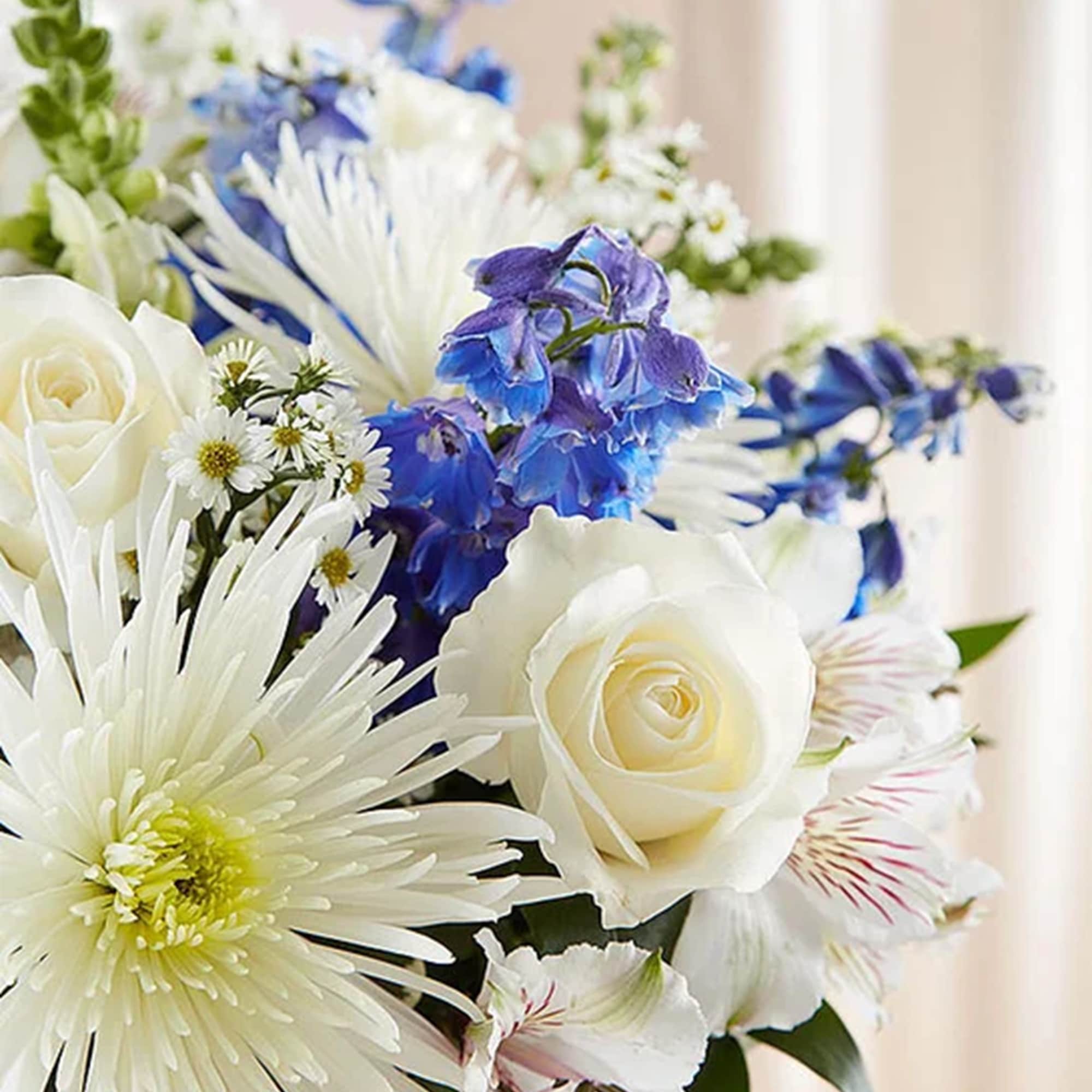 White roses and blue flowers in a mixed bouquet