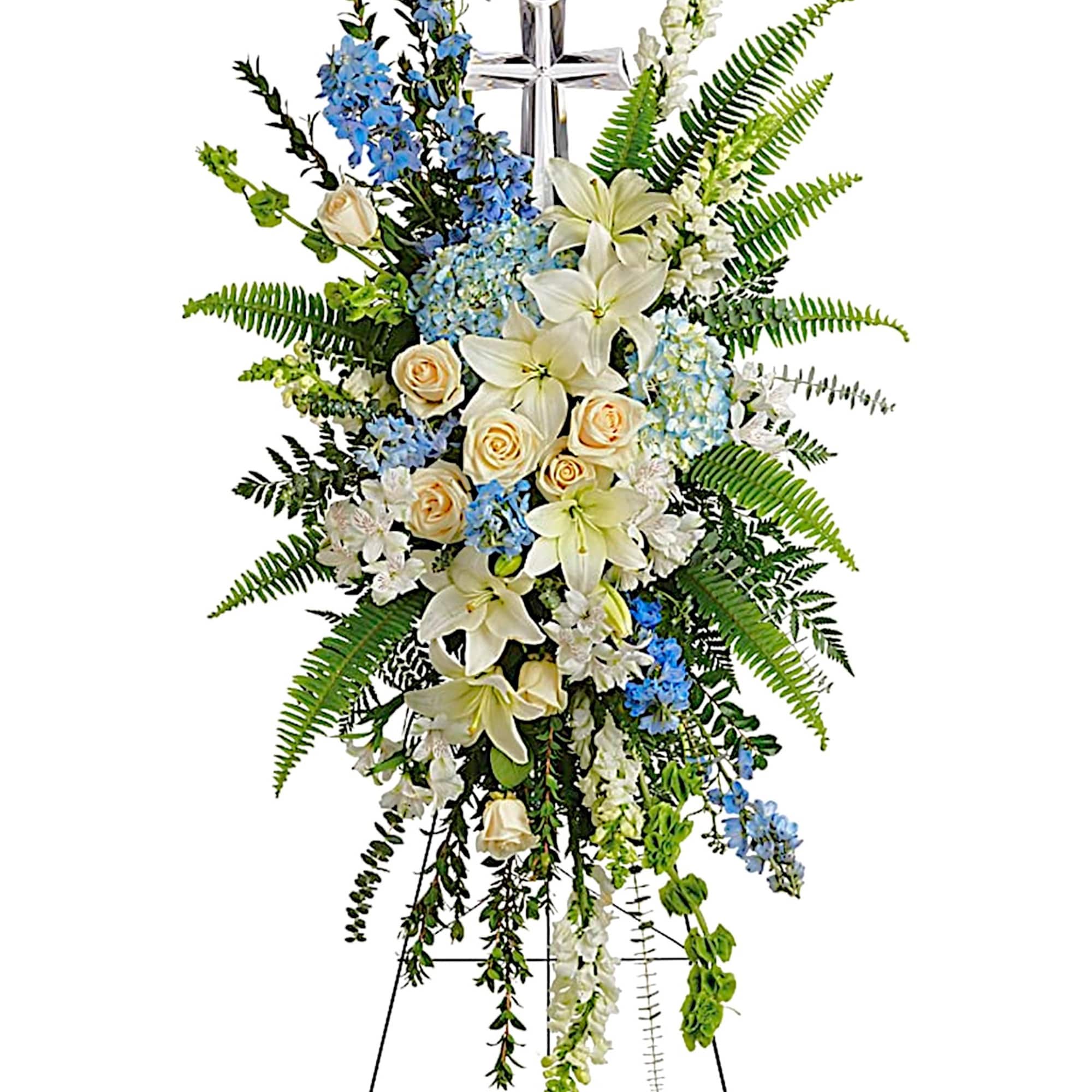 Standing floral spray with white lilies, cream roses, and blue flowers on an easel
