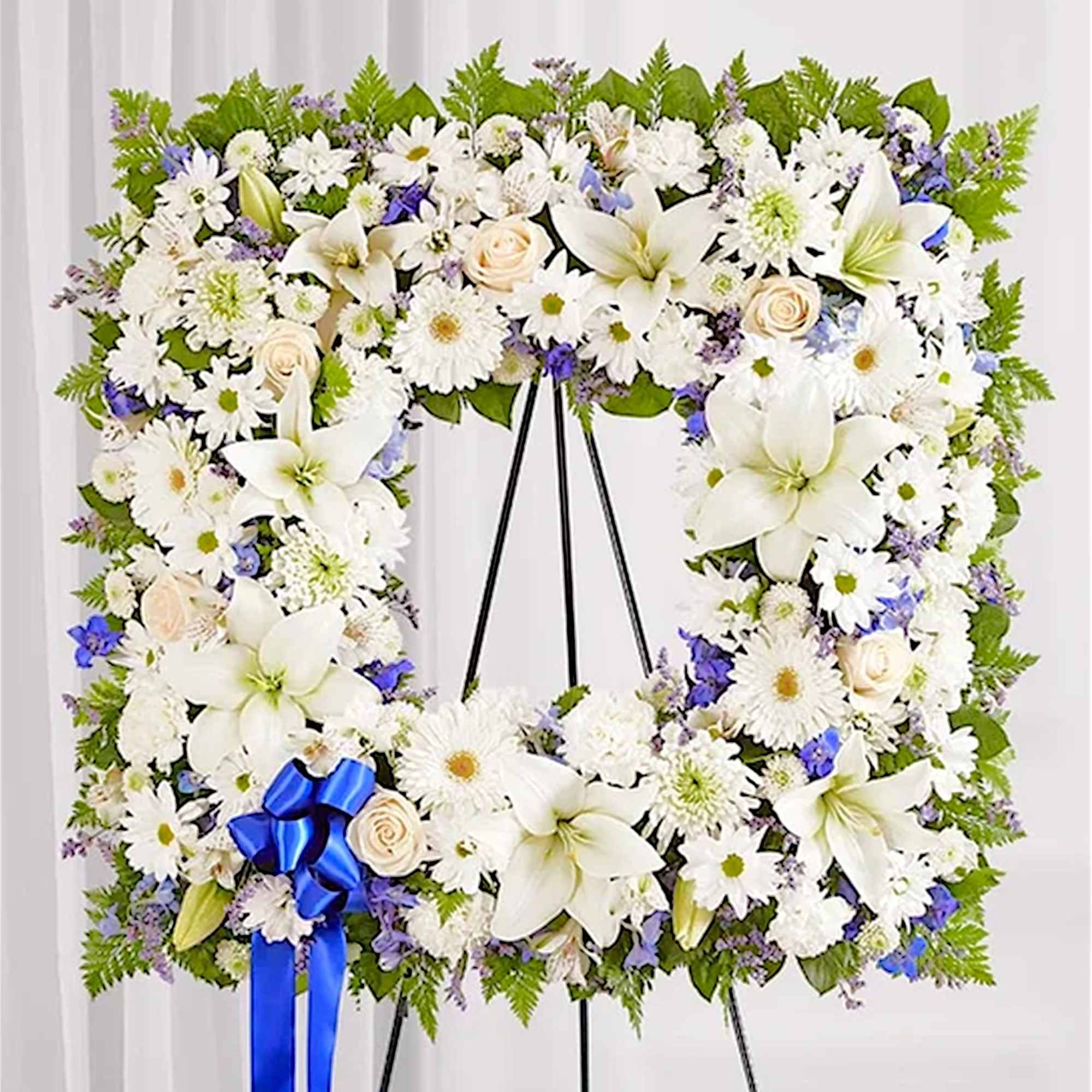 White floral standing wreath on an easel with a blue ribbon, photo 3 of 8