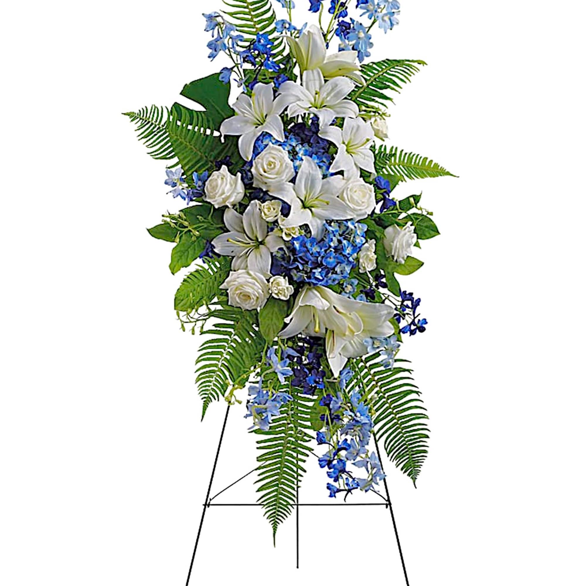 Tall standing floral spray with white lilies, white roses, and blue flowers