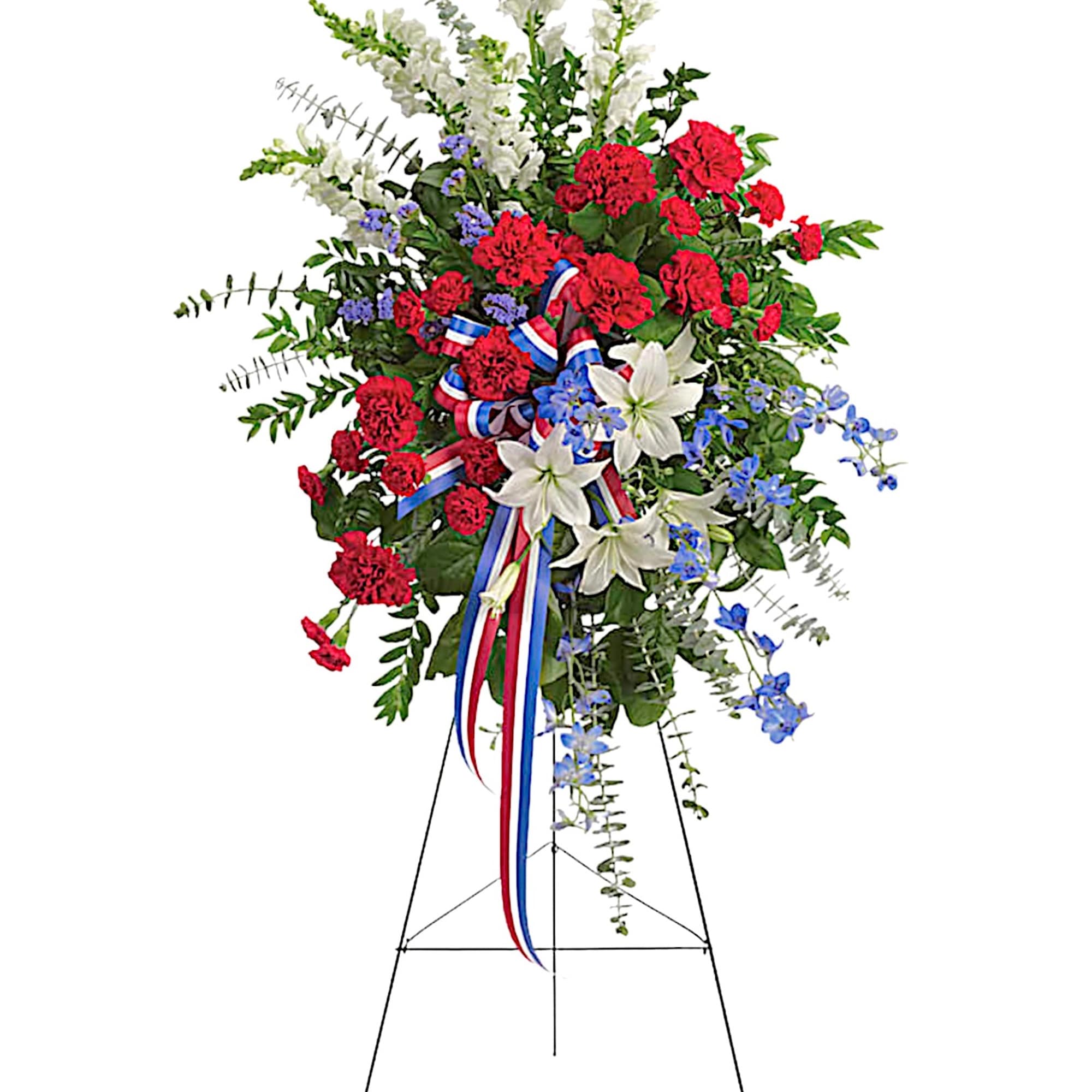 Standing floral spray with red carnations, white lilies, and blue accents on an easel
