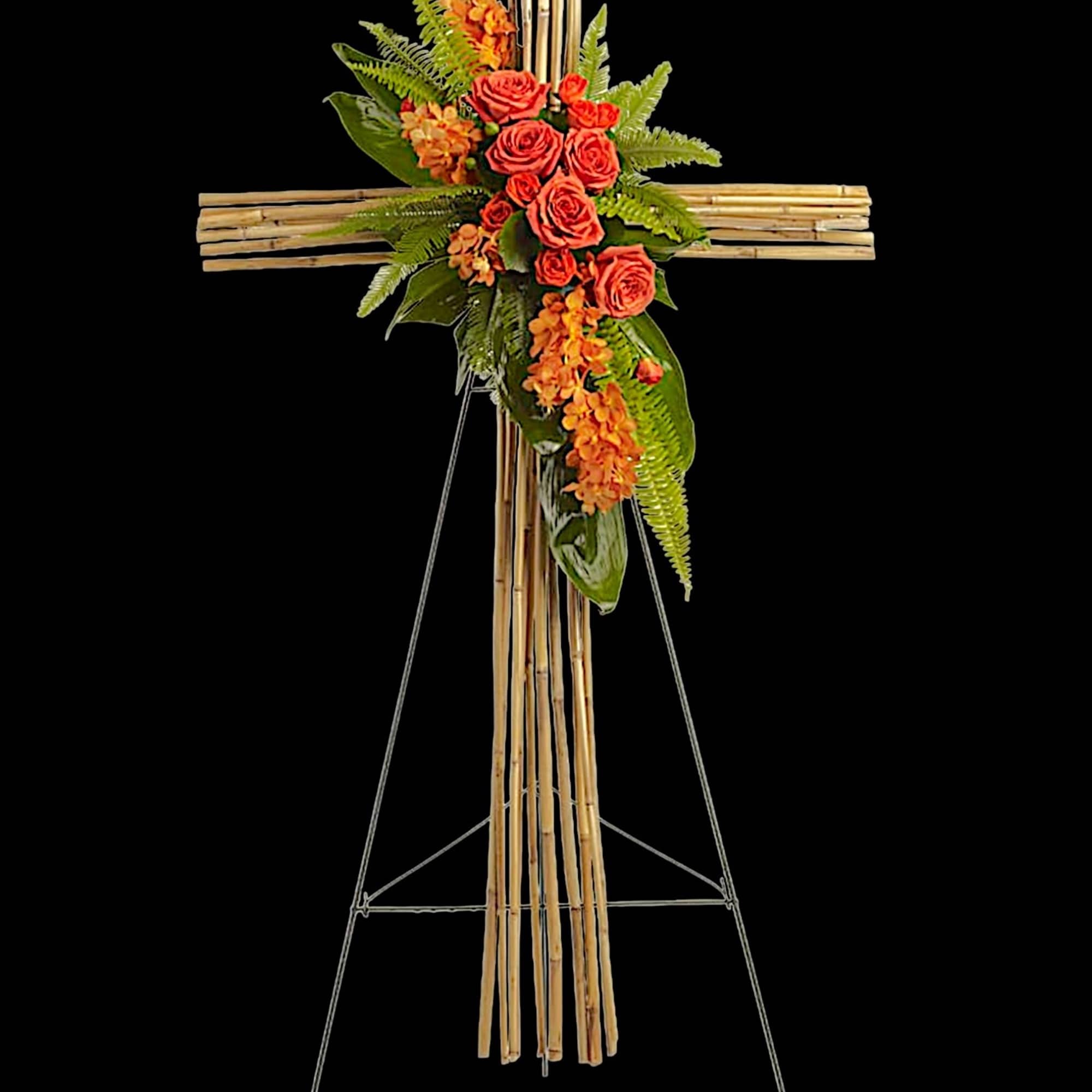 Floral cross arrangement with orange roses and orchids on a bamboo stand